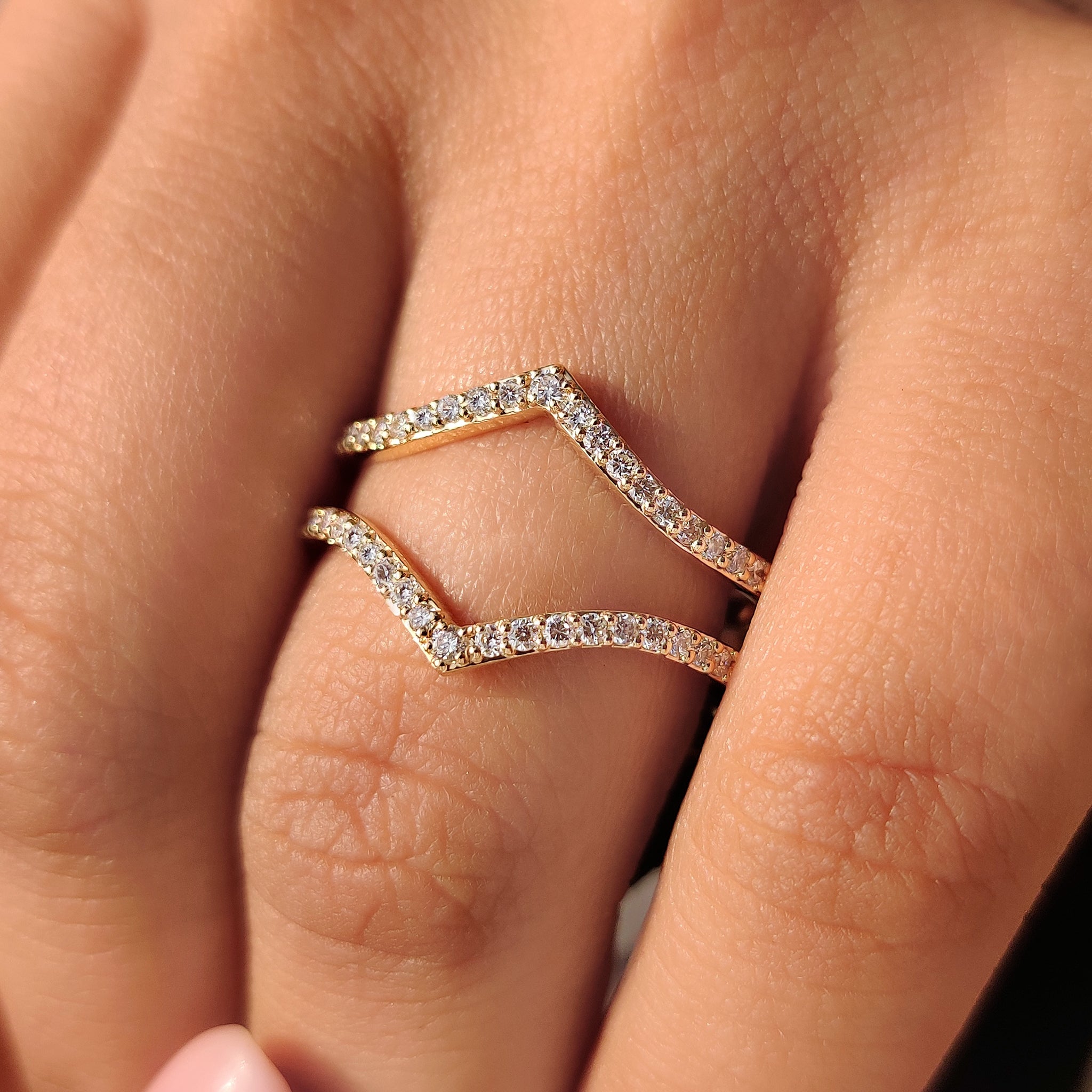 V shaped wedding band with round diamond accents.
