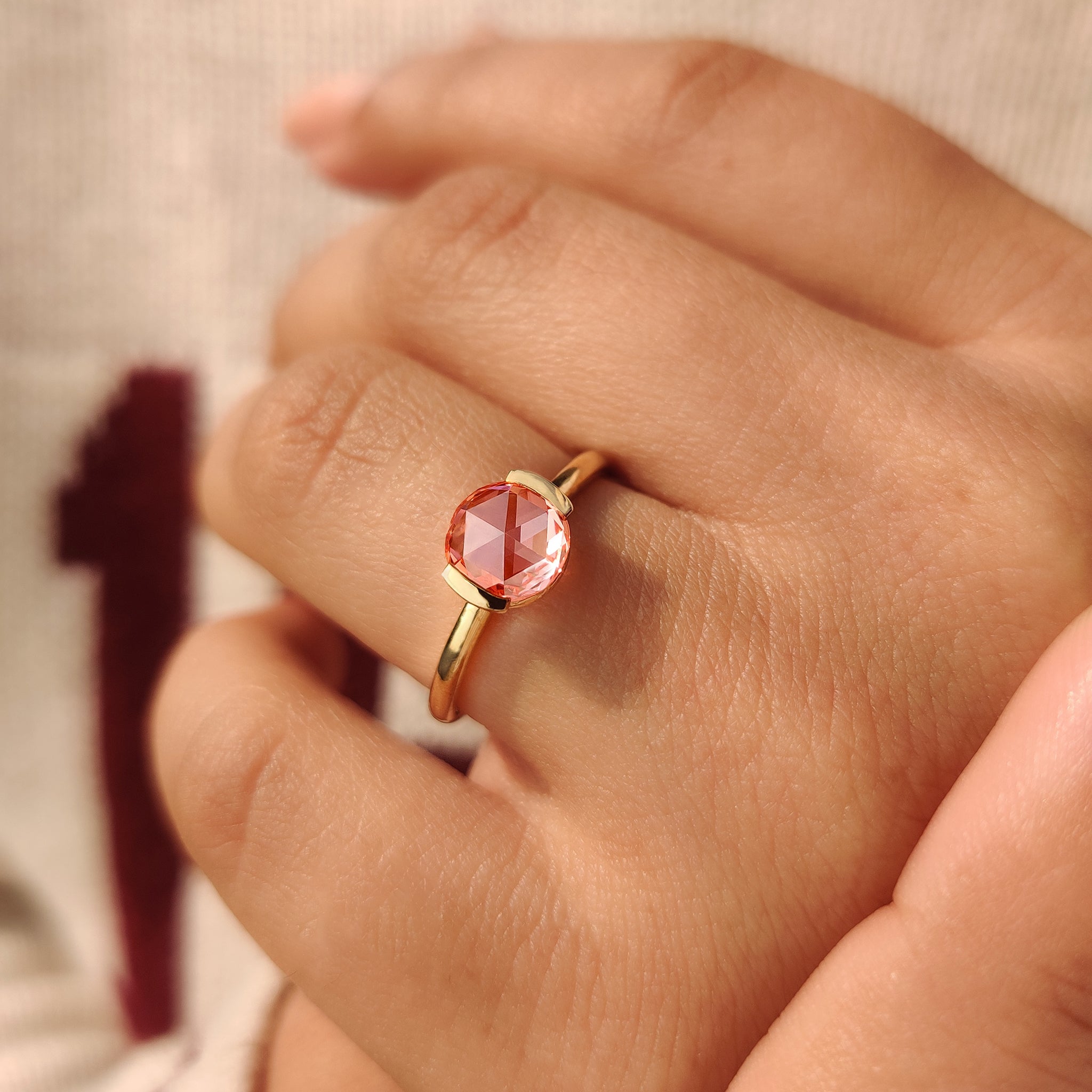 Semi bezel pink diamond solitaire ring with open gallery.
