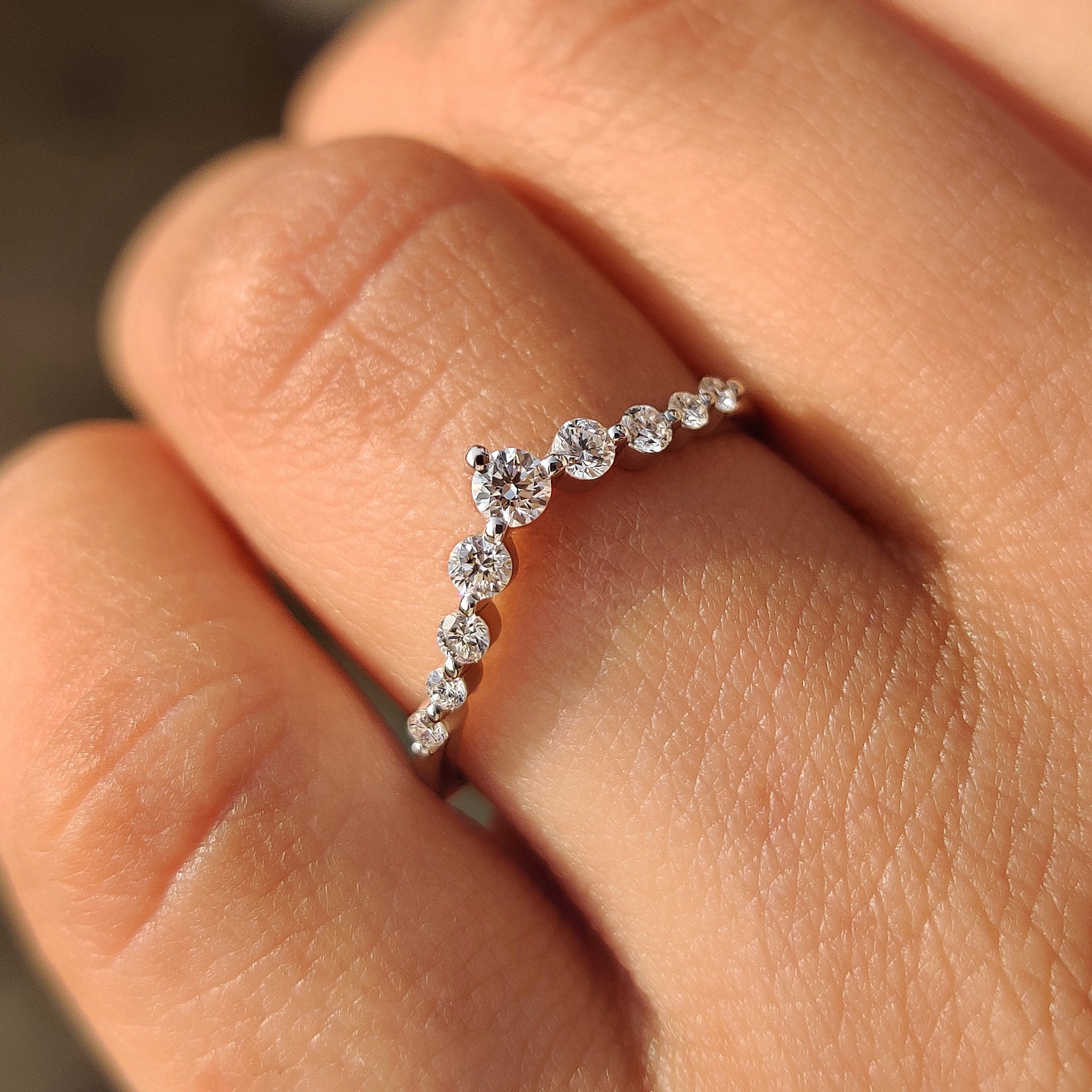 Handmade curved diamond band with round stones.
