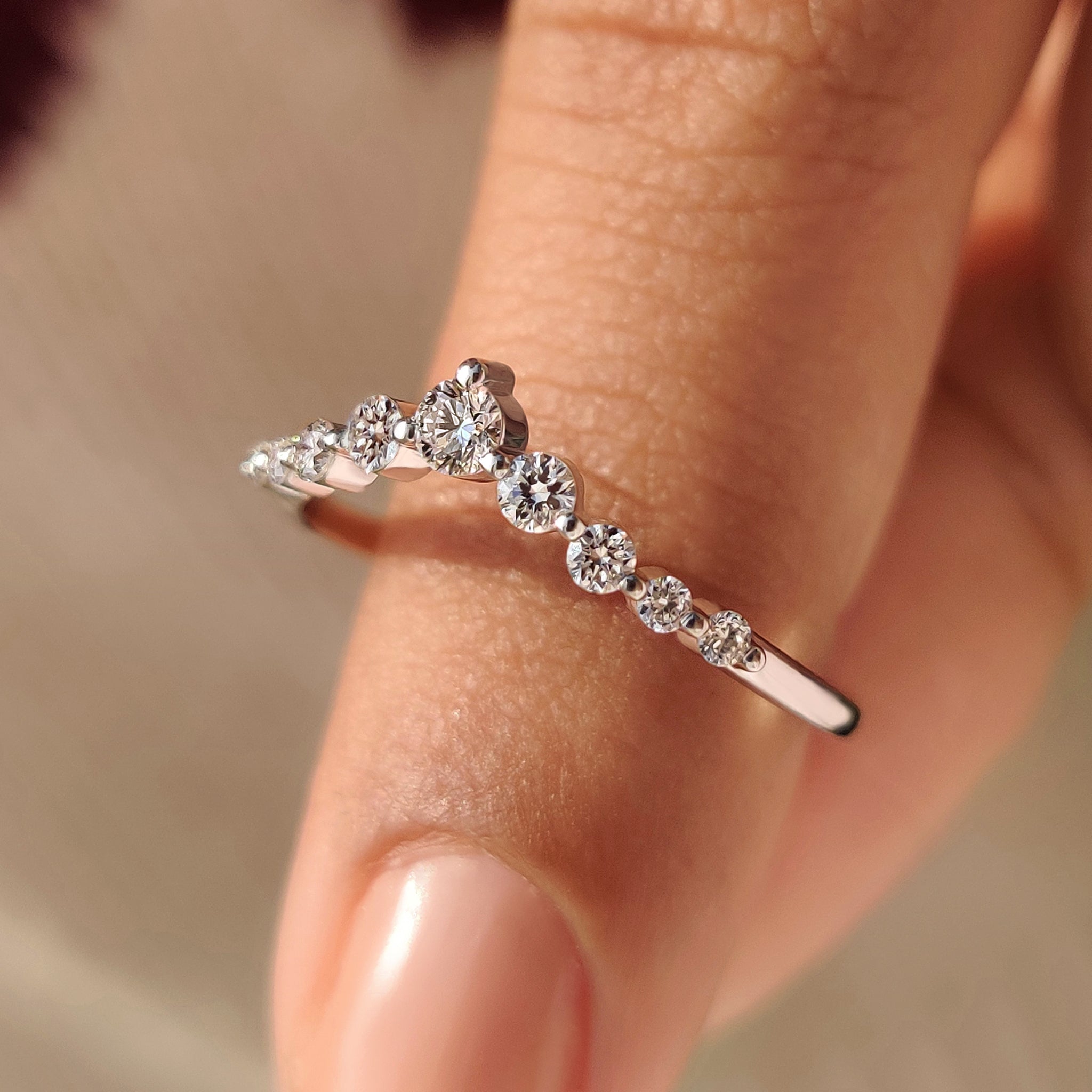 Curved wedding band with shared prong round diamonds.
