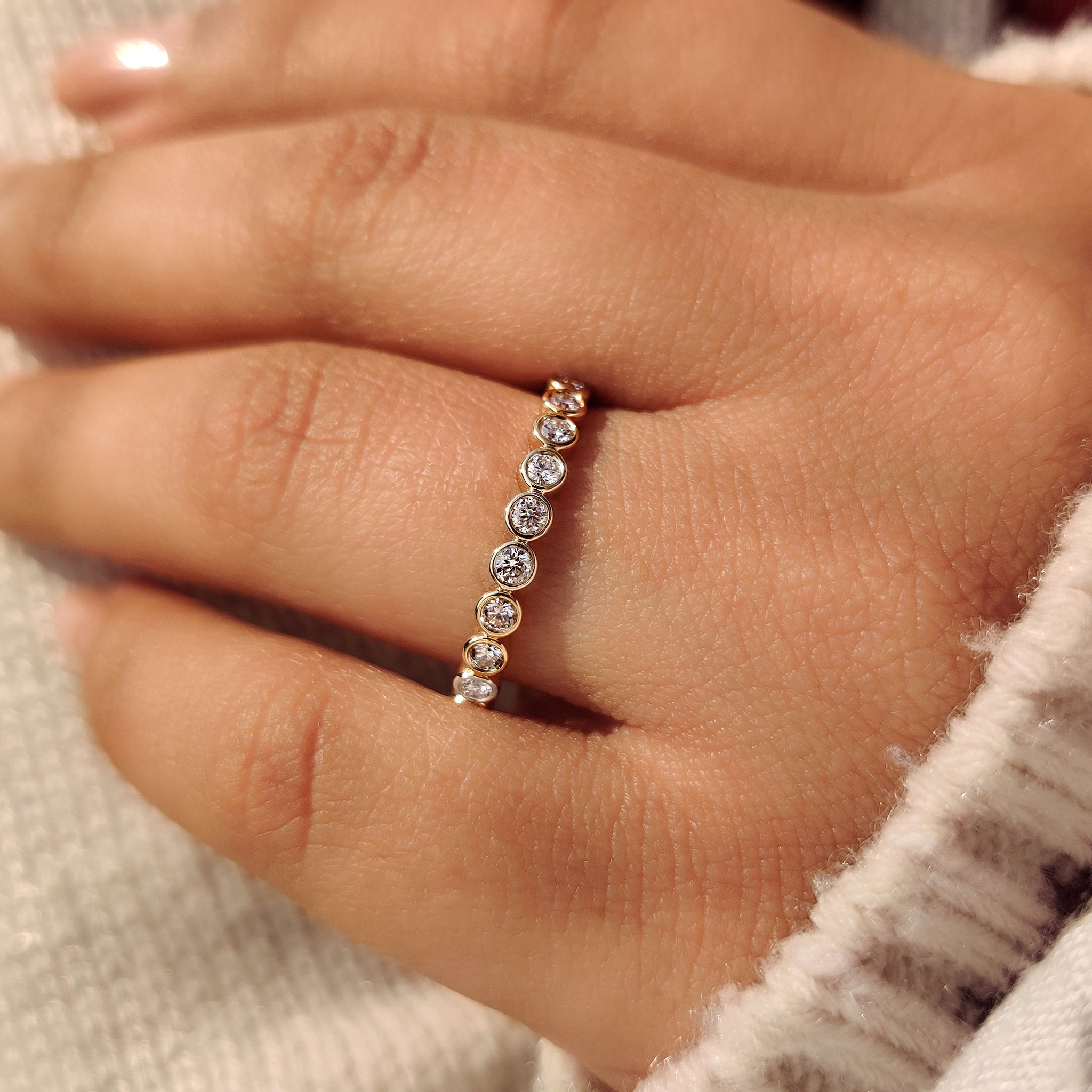 Full eternity wedding band with round bezel set diamonds.
