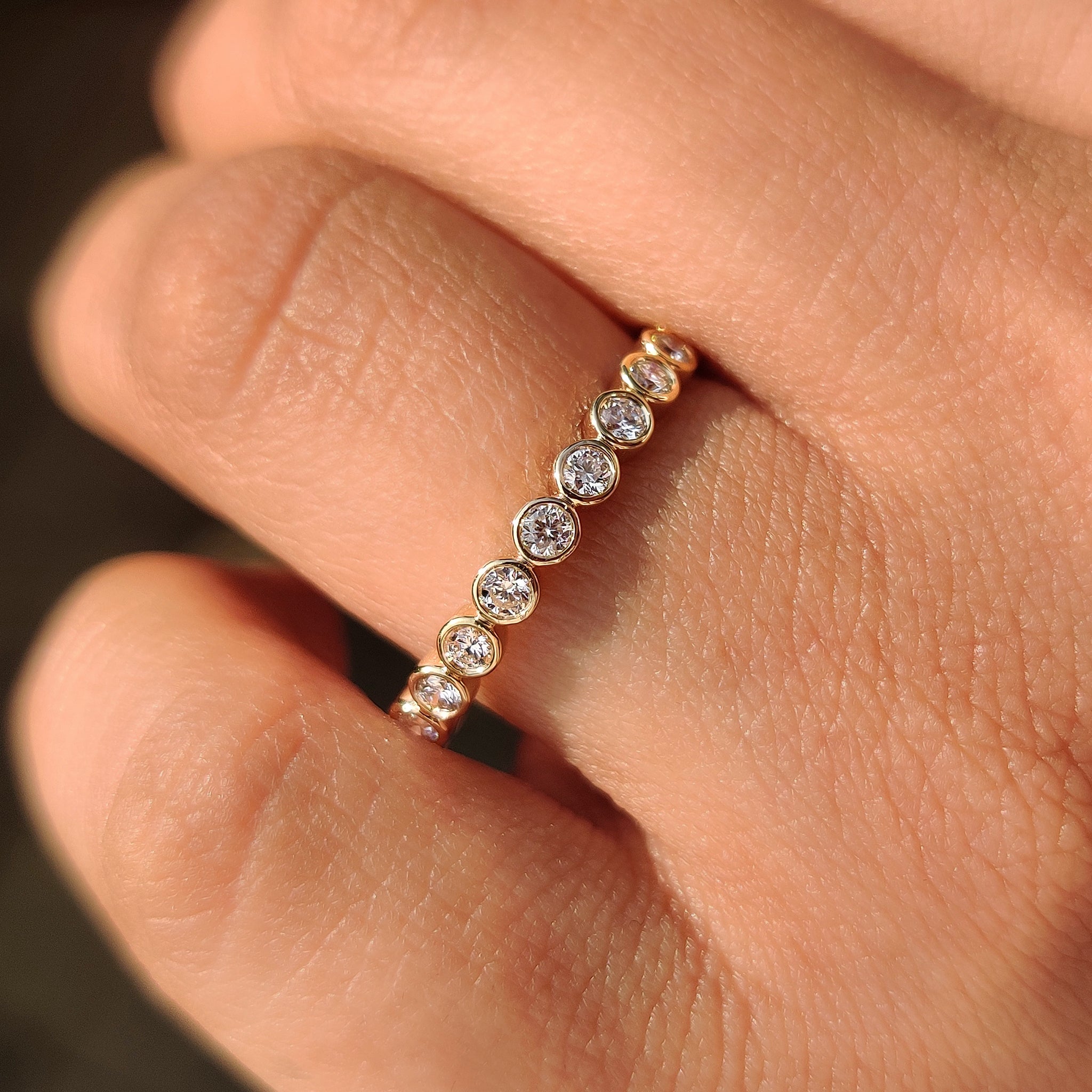 Handmade round diamond wedding band with bezel design.
