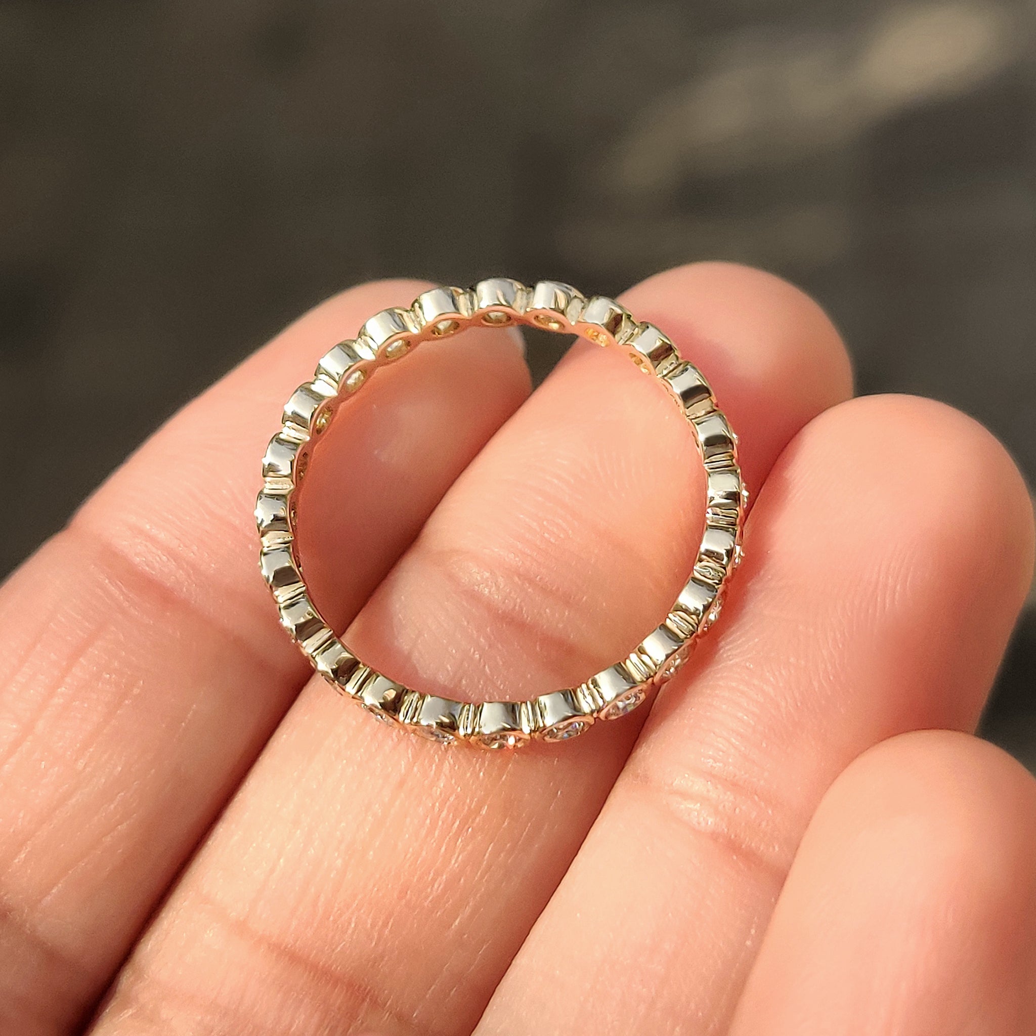 Round diamond bezel eternity wedding band by Carat Diamonds.
