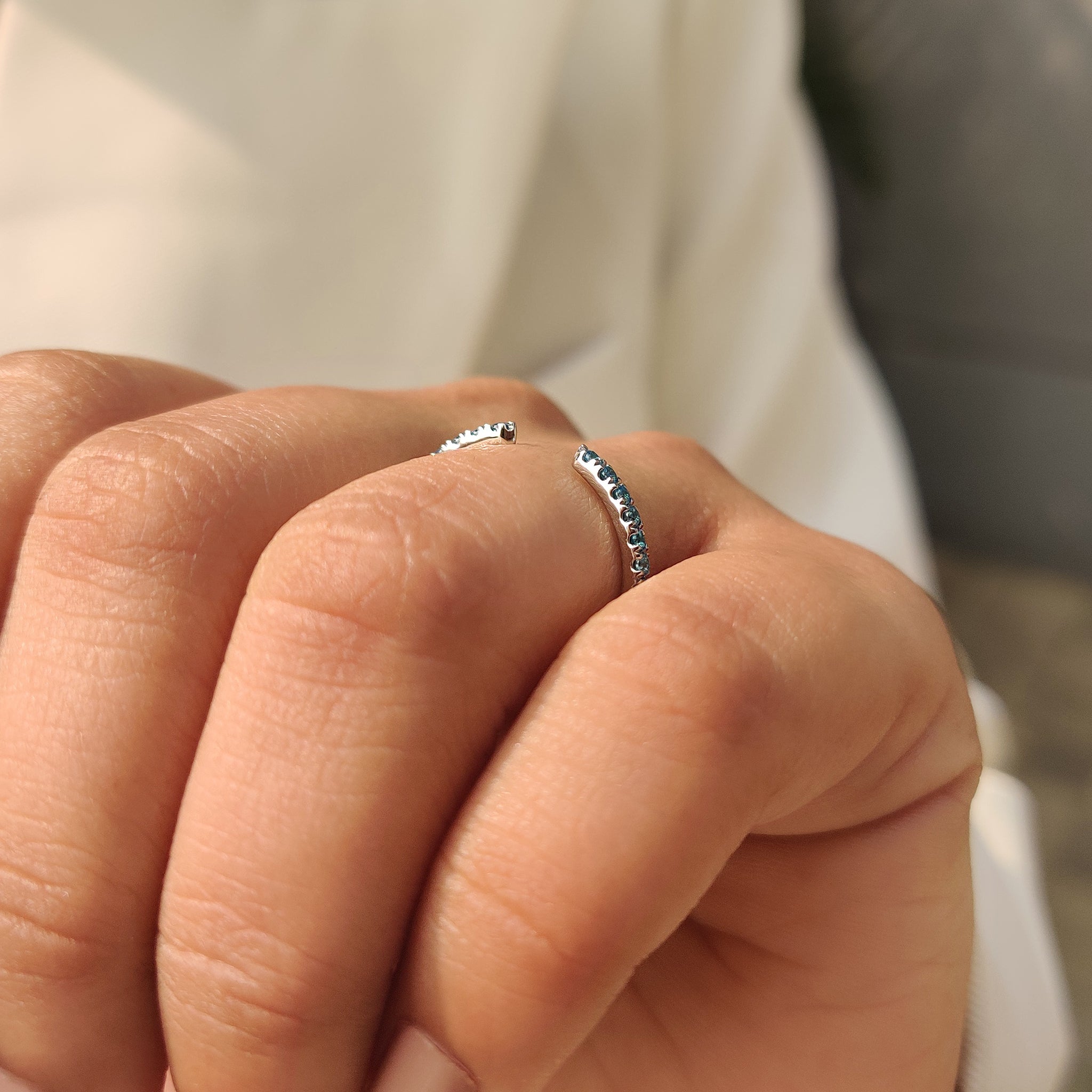 Stackable blue diamond wedding band with round cut stones.
