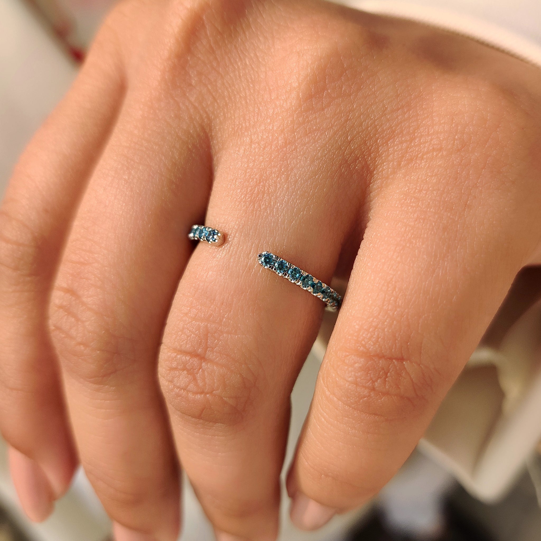 Blue diamond band designed with round stones and open gap.
