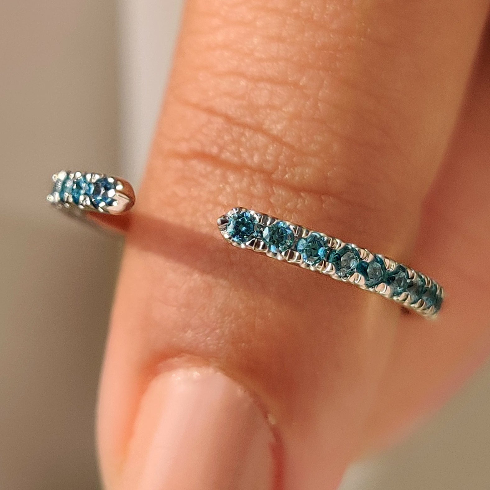 Blue diamond wedding band with round diamonds and open gap style.
