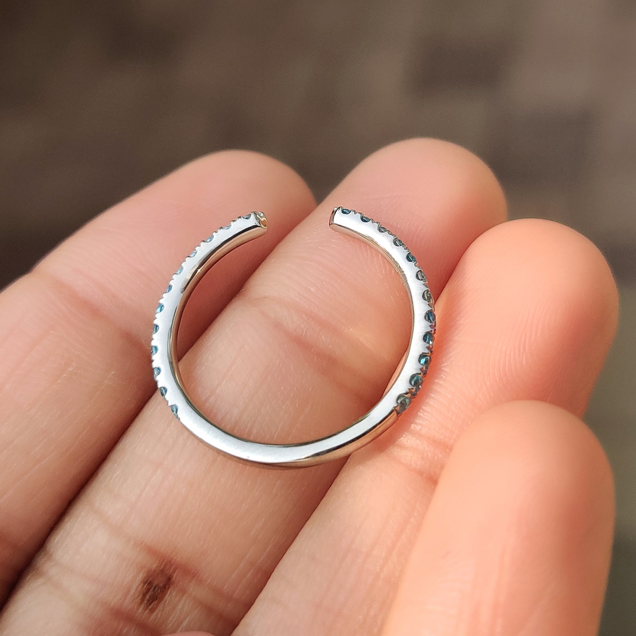 Open gap blue diamond band in 3/4 eternity style.
