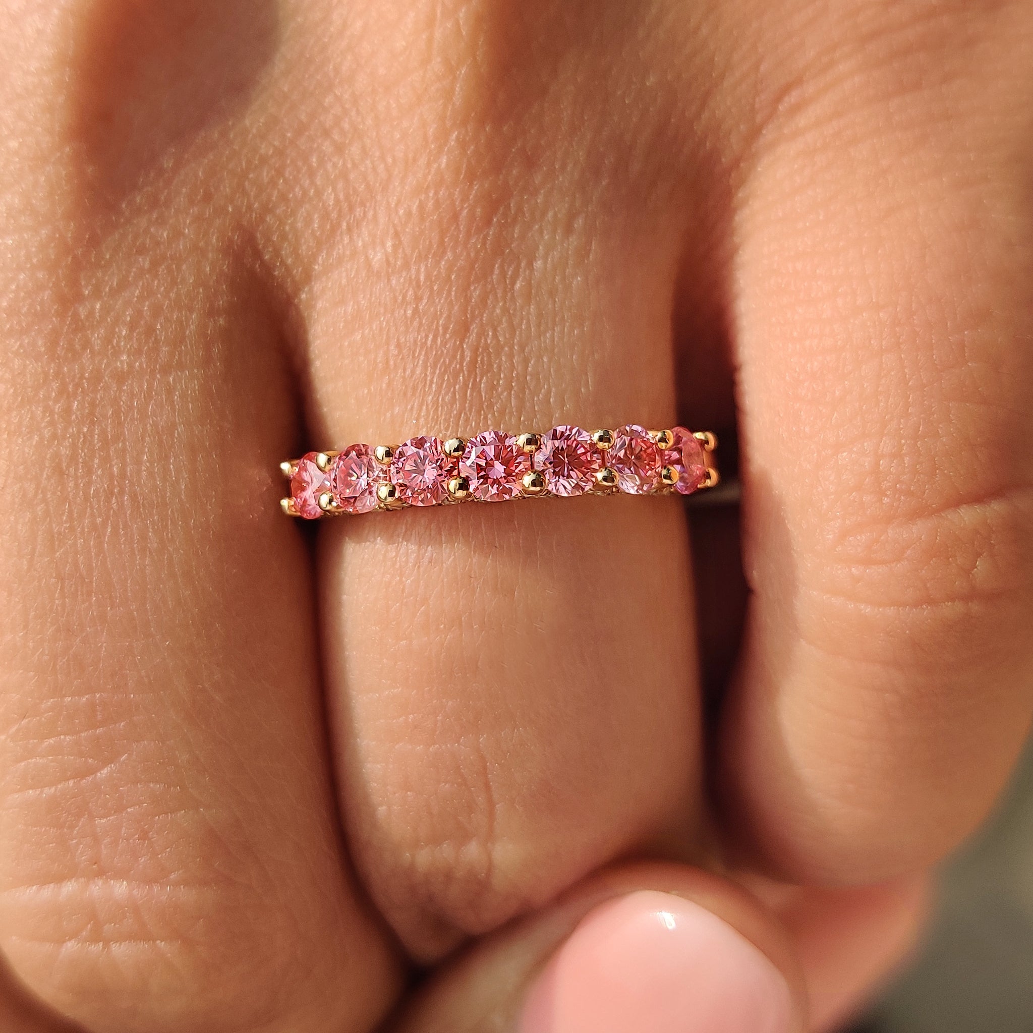 Handmade pink diamond wedding band with shared prongs.
