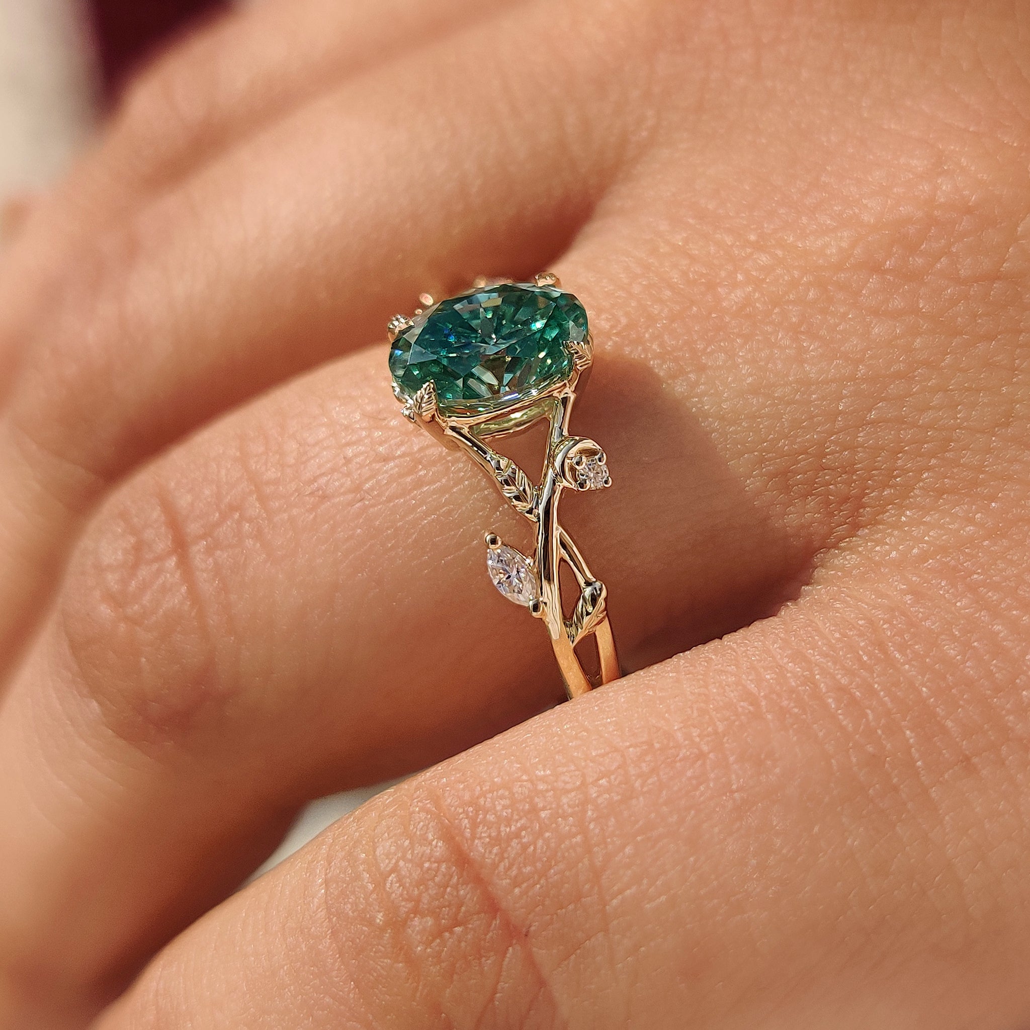Oval moissanite ring featuring marquise and round side stones.
