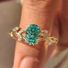 Oval cut green moissanite ring with marquise side stones.
