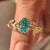 Oval cut green moissanite ring with marquise side stones.
