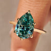 Pear cut moissanite ring cyan blue solitaire.
