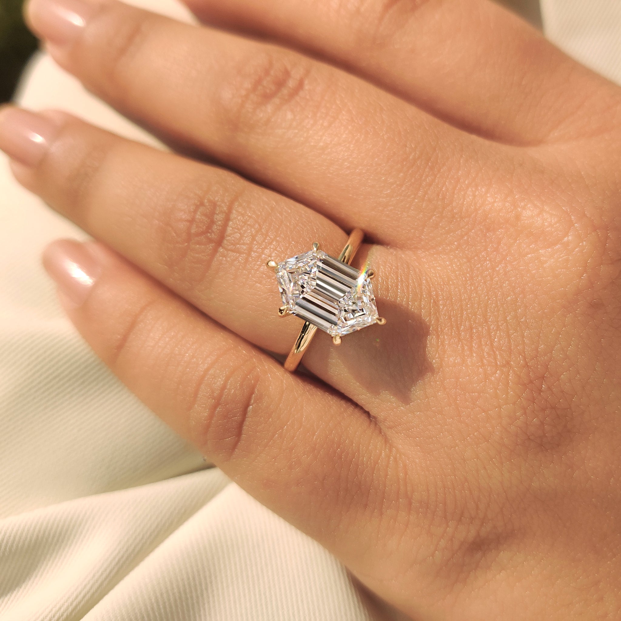 Hexagon step cut diamond ring in six claw prong setting
