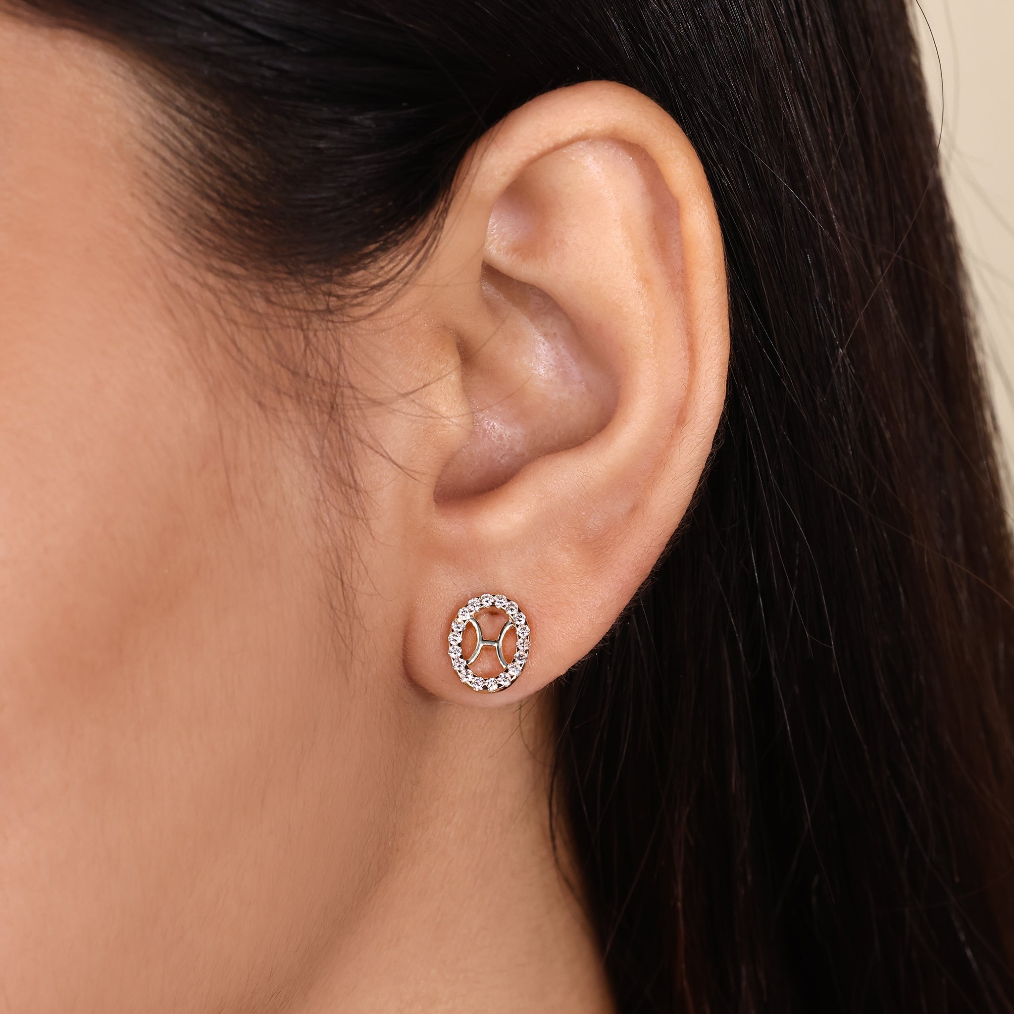 Custom Pisces zodiac earrings with yellow gold halo studs.

