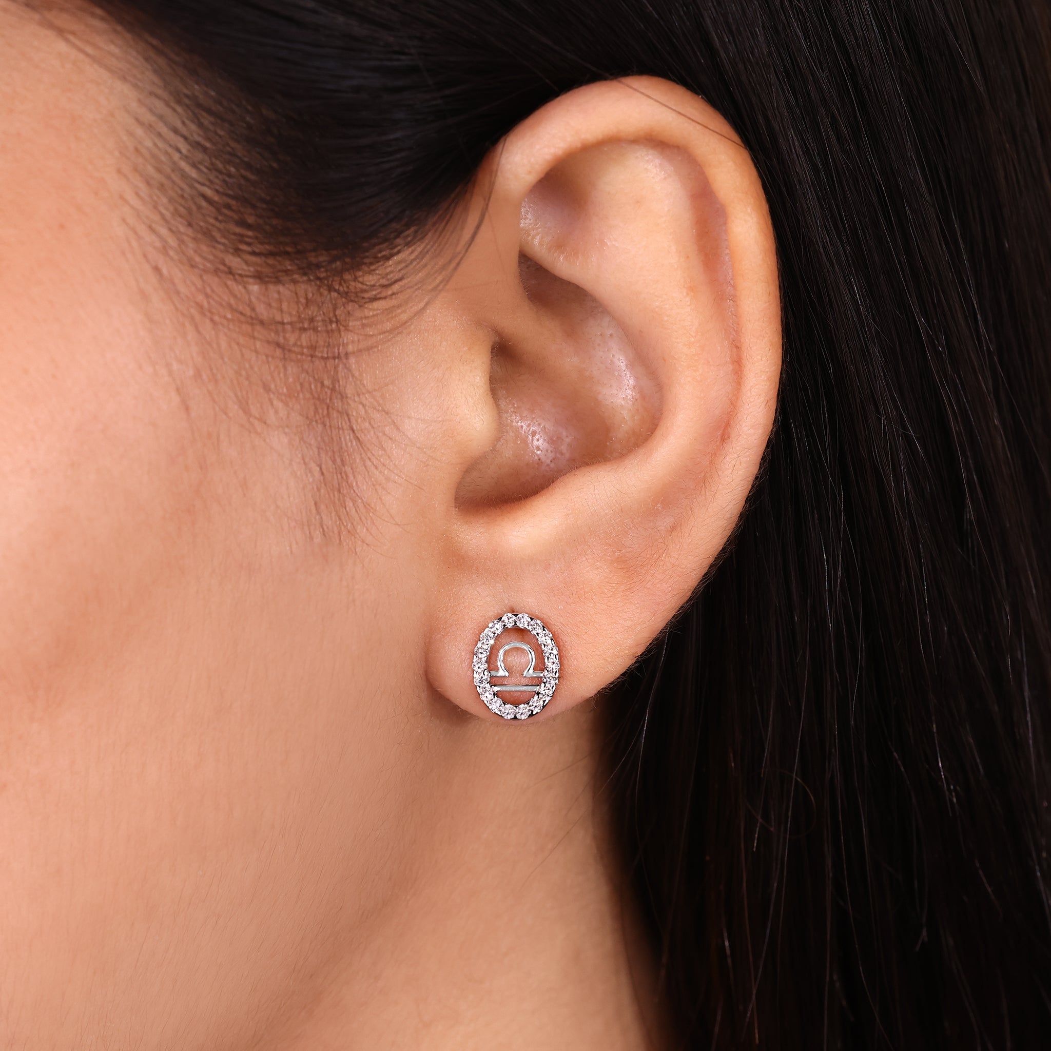 Custom Libra zodiac earrings in white gold with halo diamonds.
