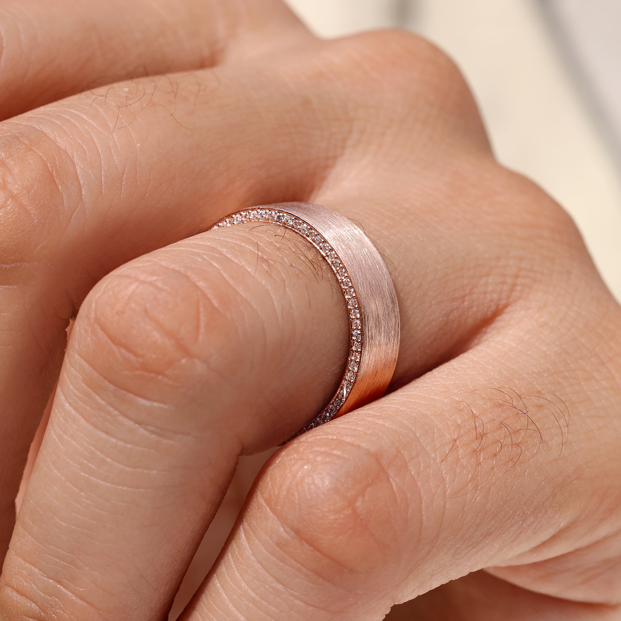 Matte finish men’s eternity ring with round cut stones.
