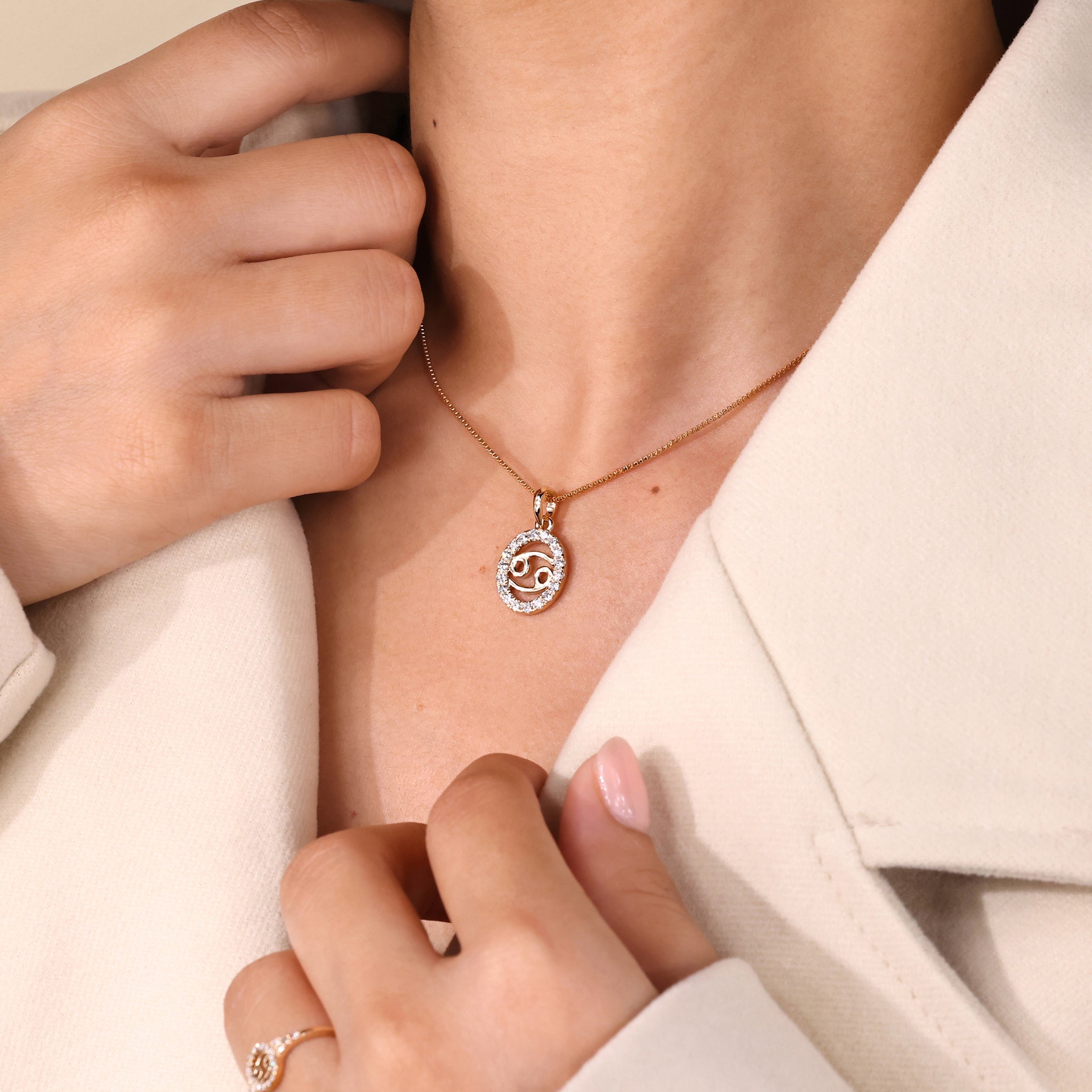 Carat Diamonds Cancer zodiac pendant in gold with halo diamond setting.