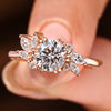 Round diamond engagement ring with marquise side stones.

