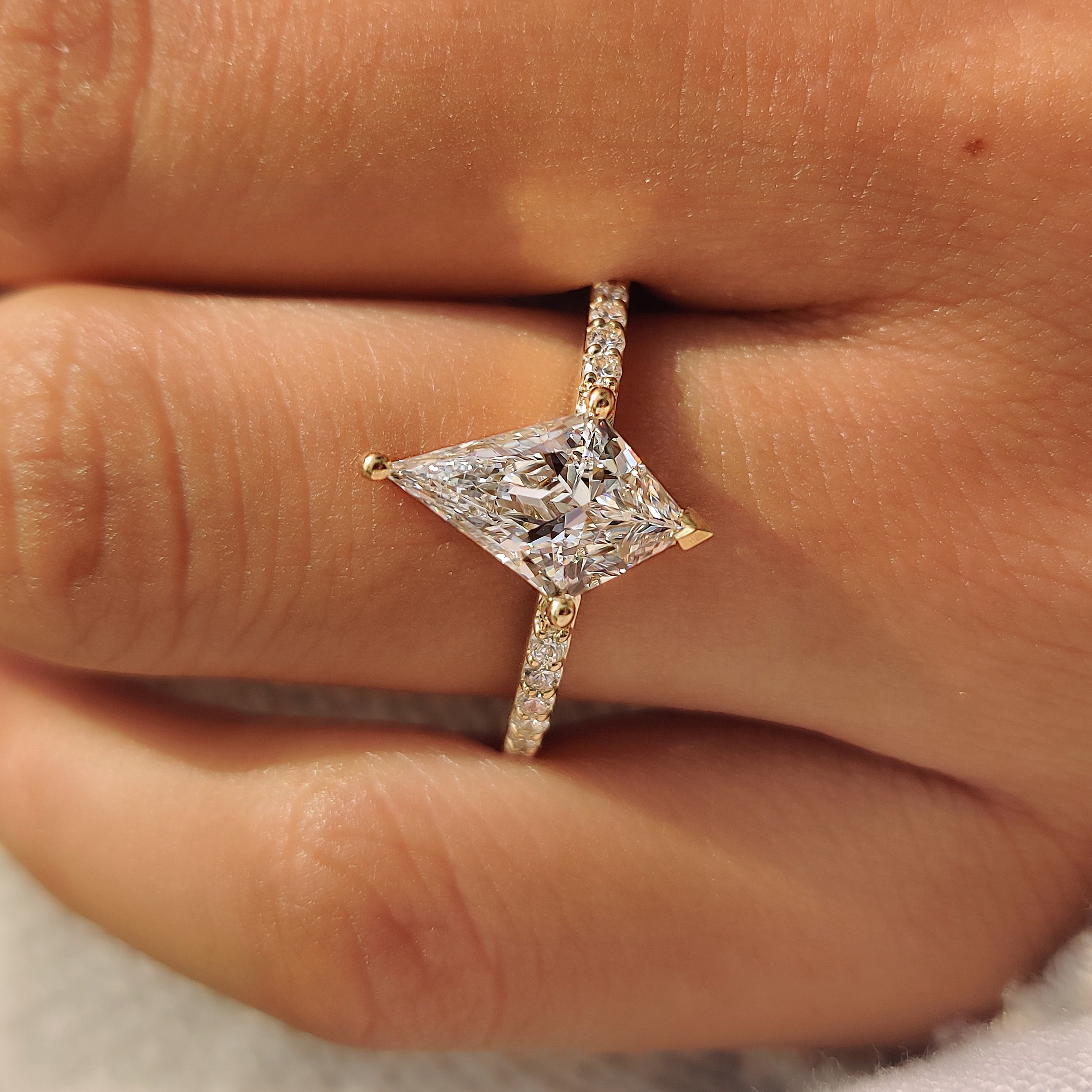 V shaped prongs holding the pointed ends of a kite cut diamond.
