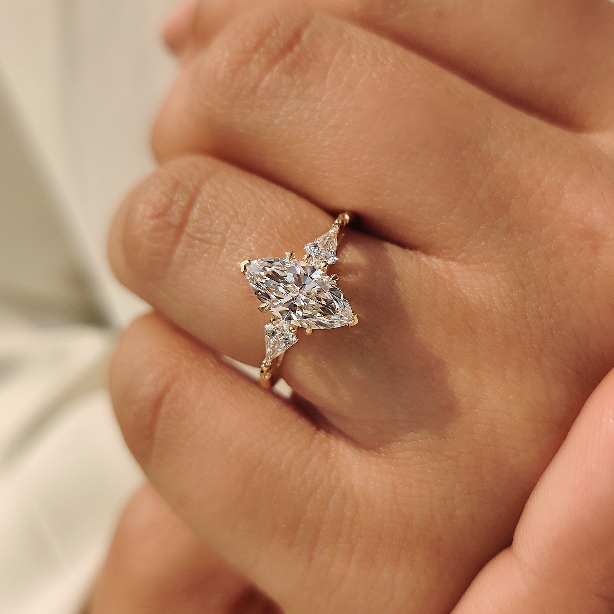 Three stone diamond marquise ring with kite side accents
