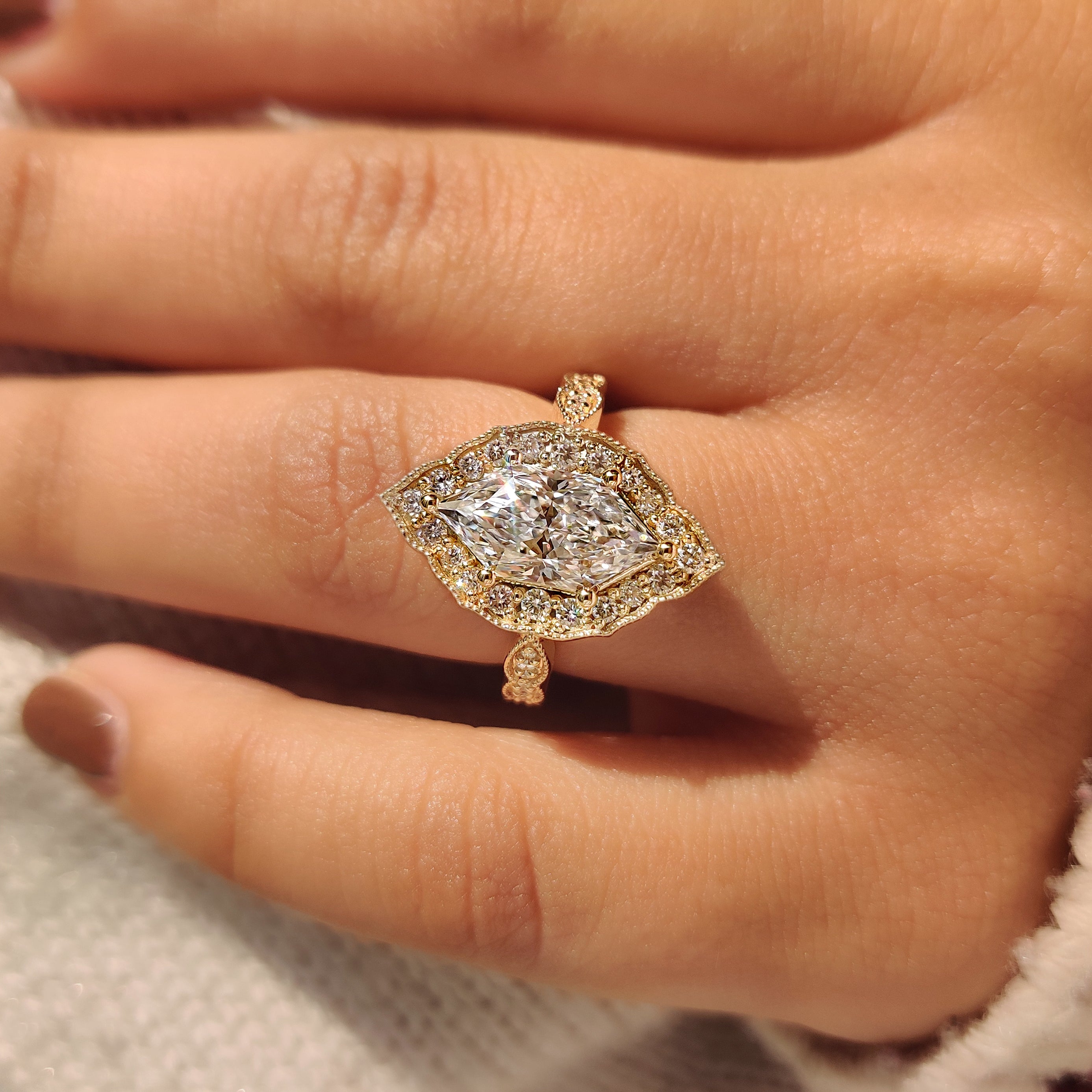 Dutch marquise diamond ring with round halo side stones.

