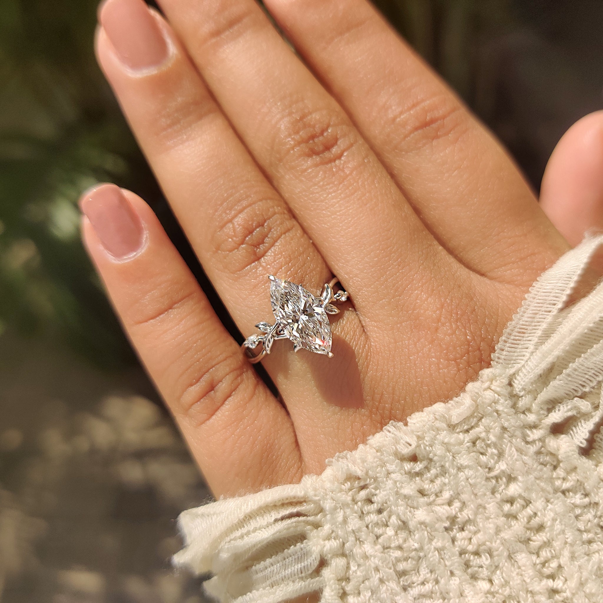 Marquise diamond ring with round accents and compass prongs.
