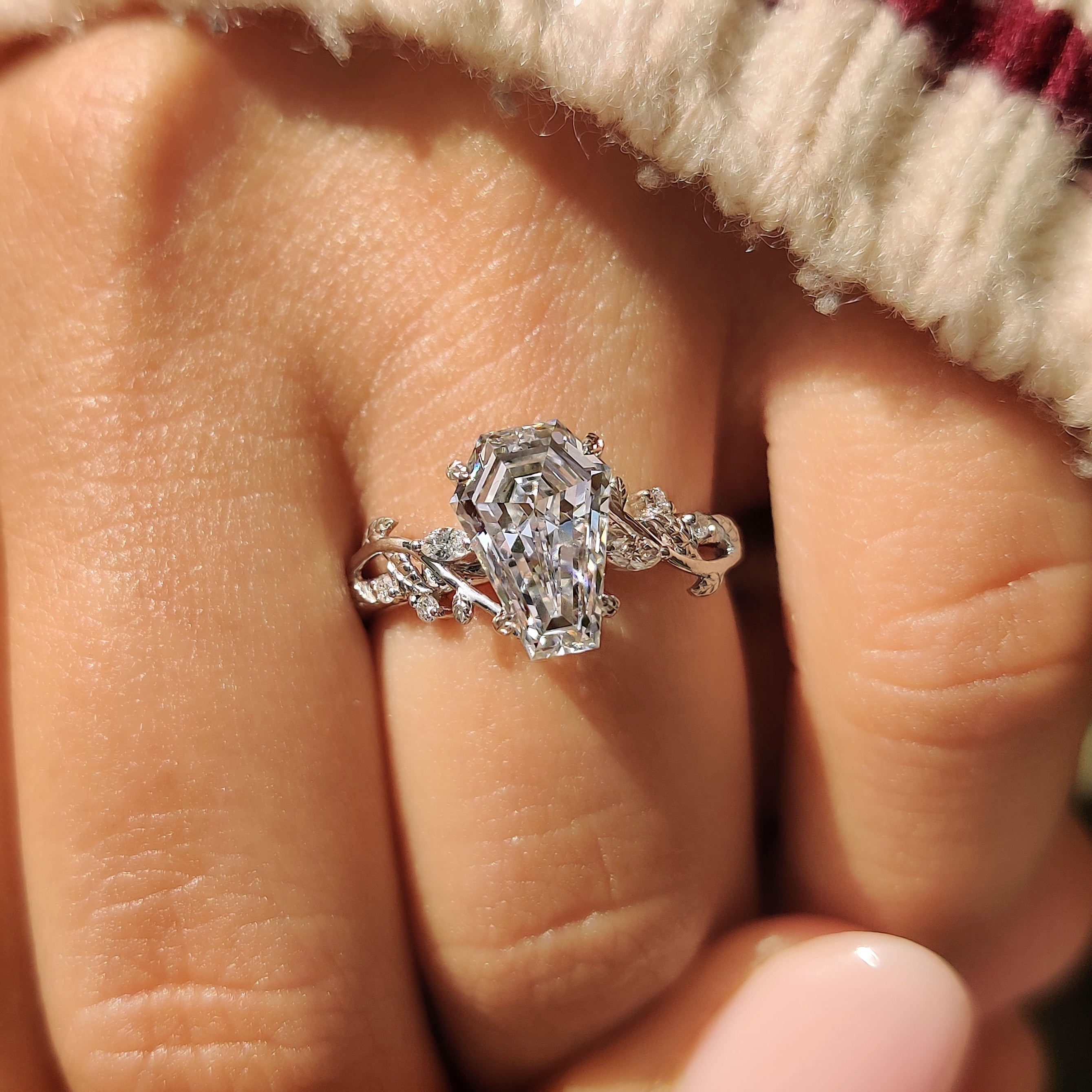 Nature inspired coffin engagement ring with side stone accents.
