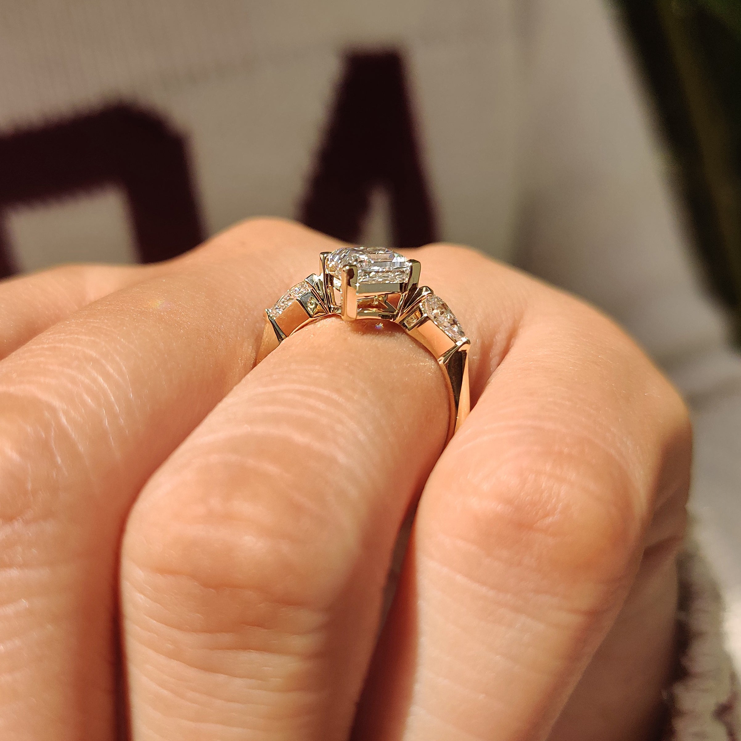 Three stone lozenge engagement ring with kite side diamonds
