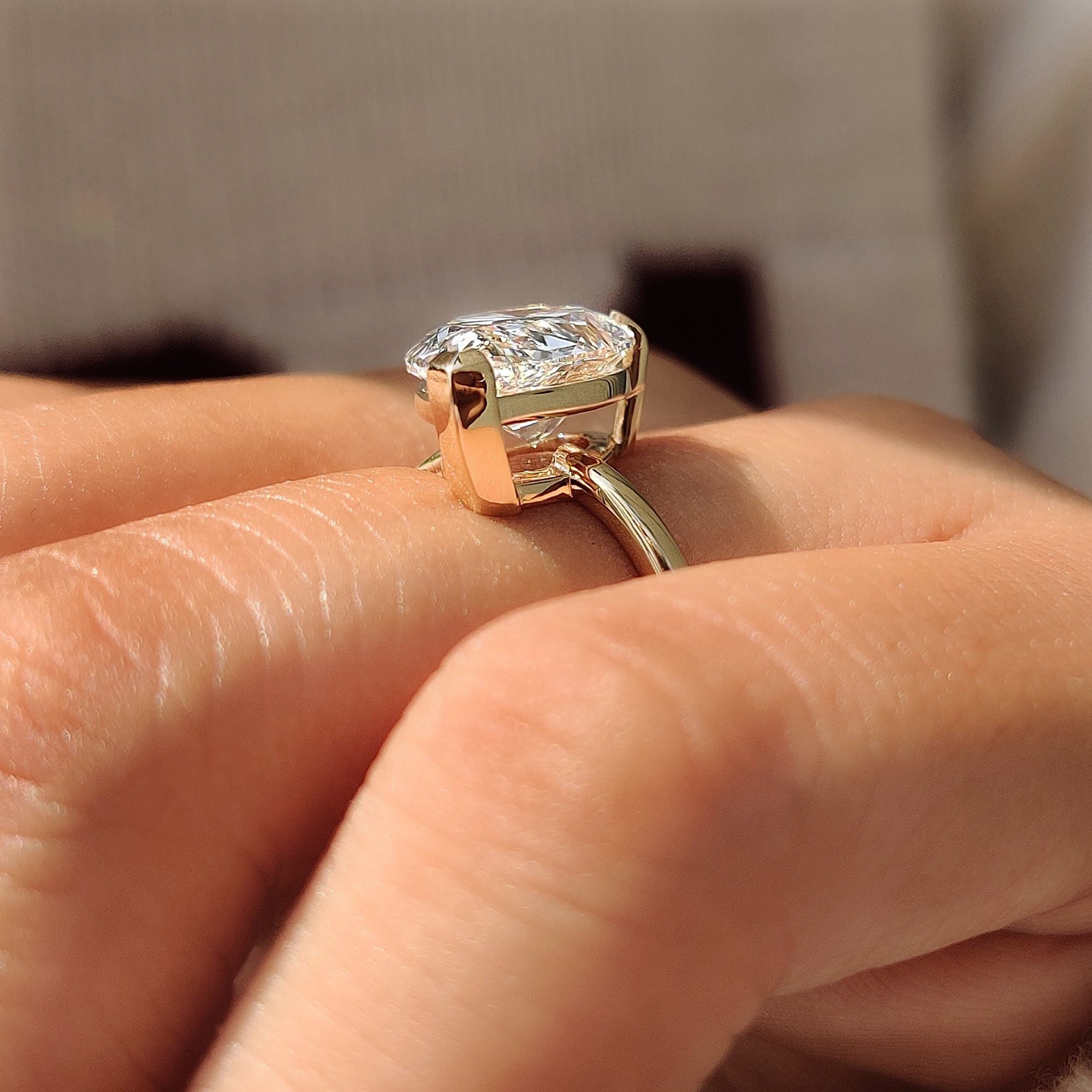 Side view of a pear cut diamond in an open basket setting.
