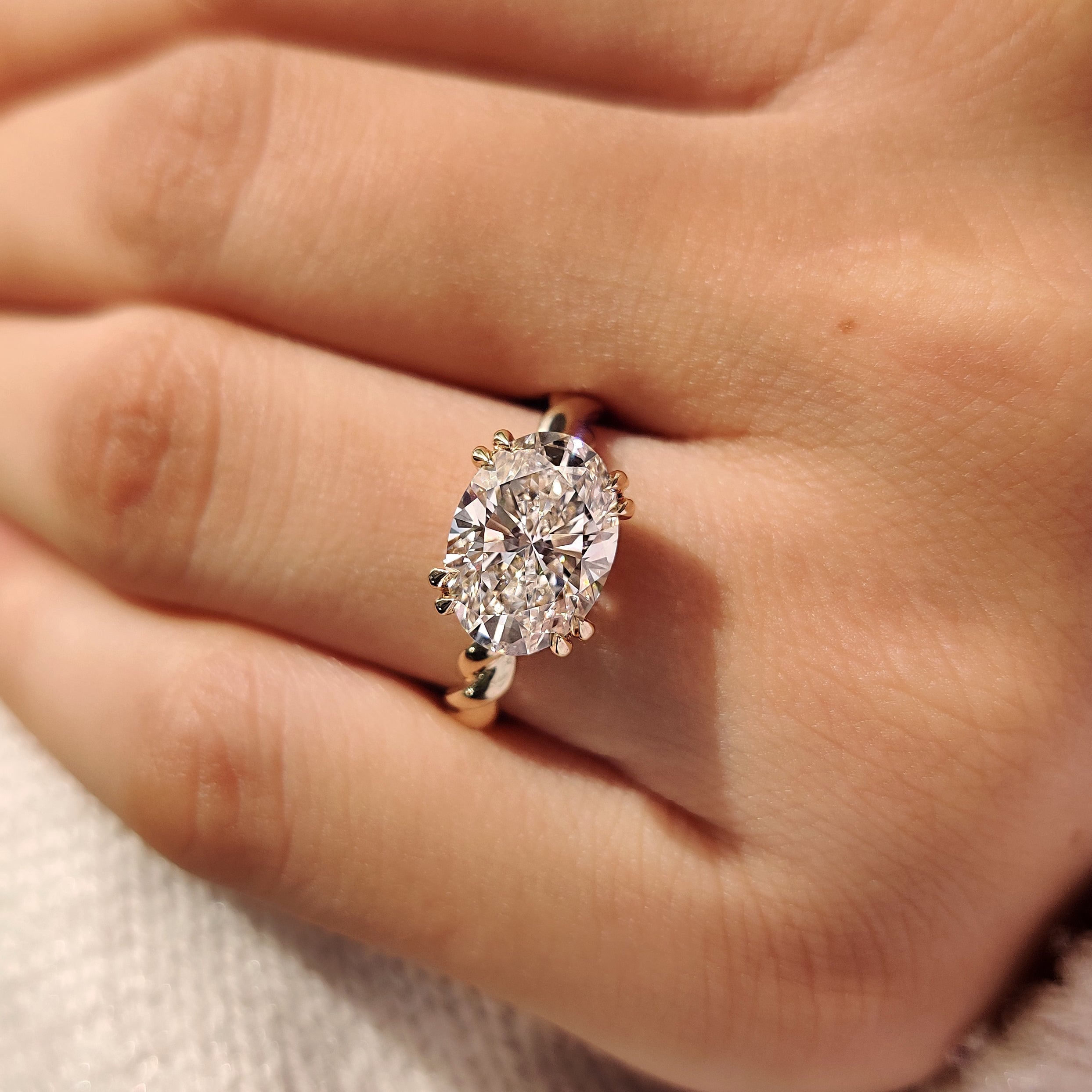Handmade oval engagement ring with round hidden halo accents
