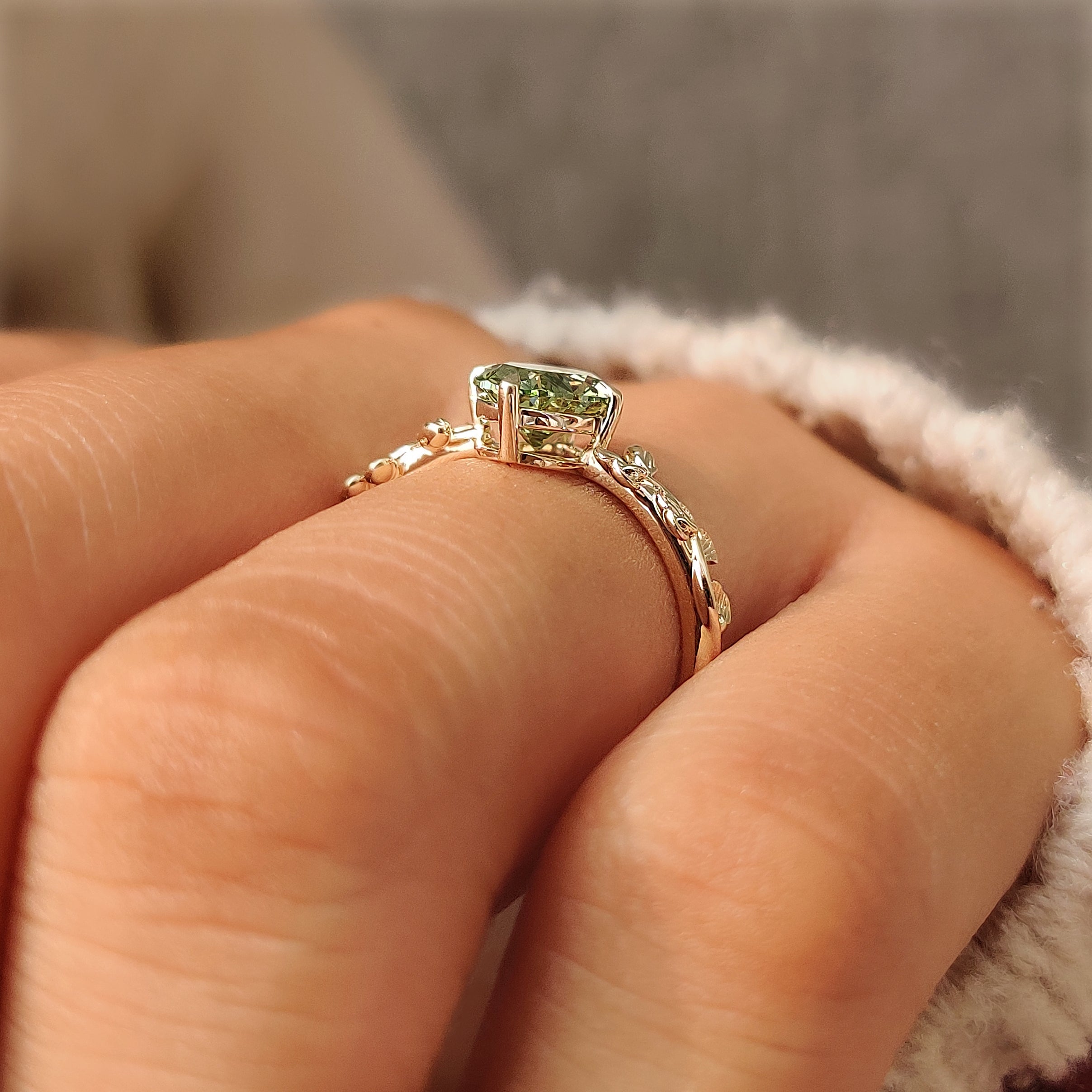 Nature inspired solitaire ring with a green center diamond.
