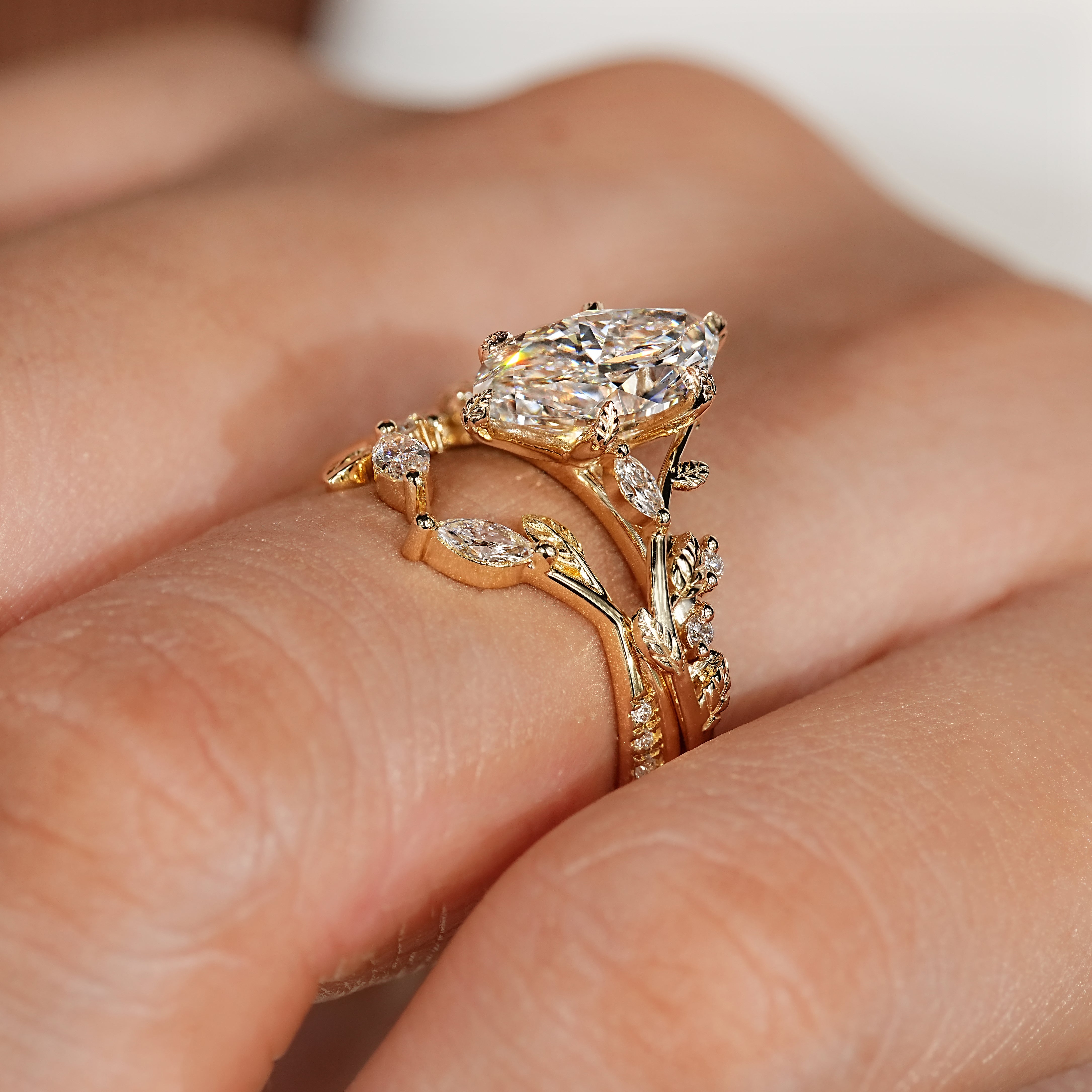 Marquise engagement ring with leaf style prong and wedding band
