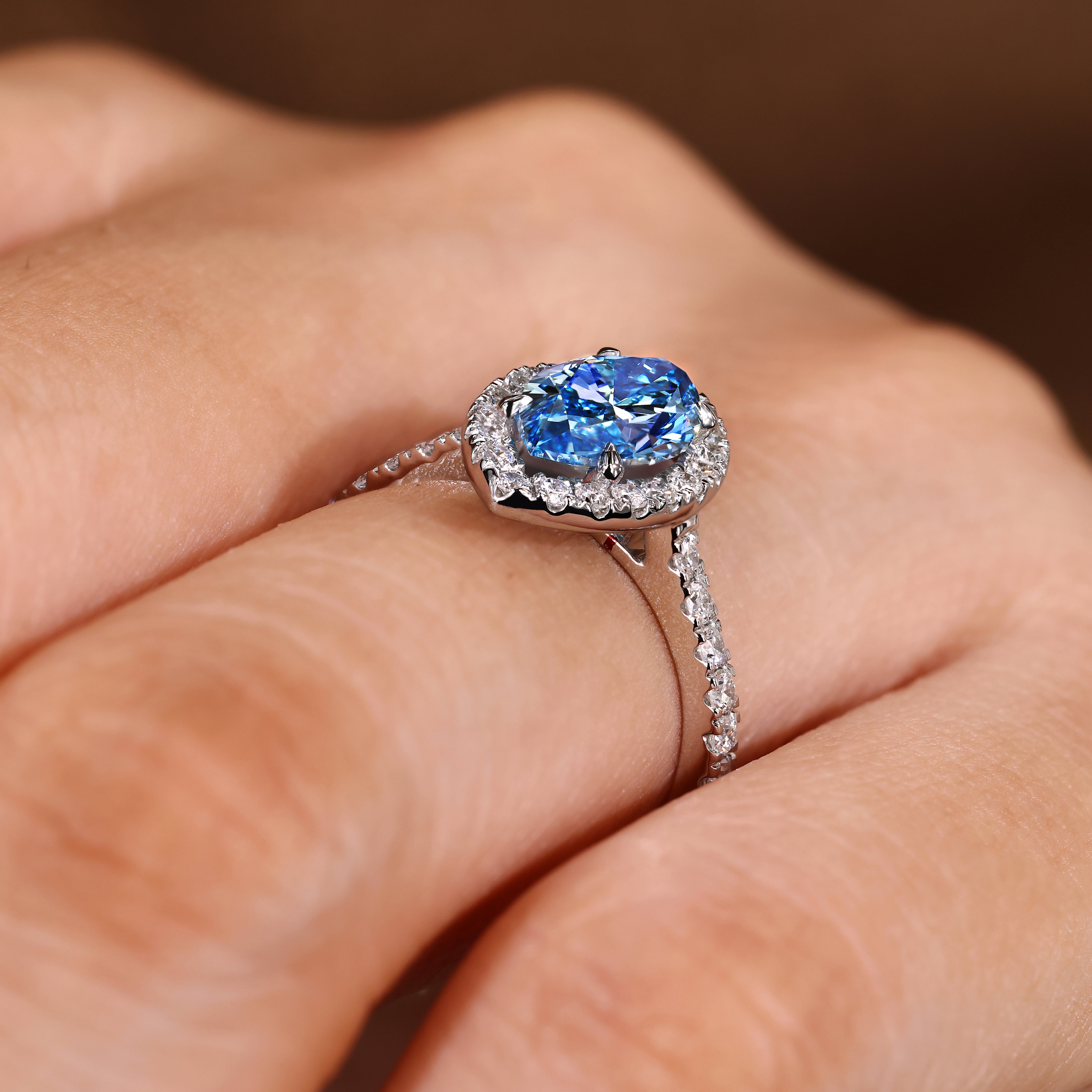 Blue center lab diamond ring with four claw prongs
