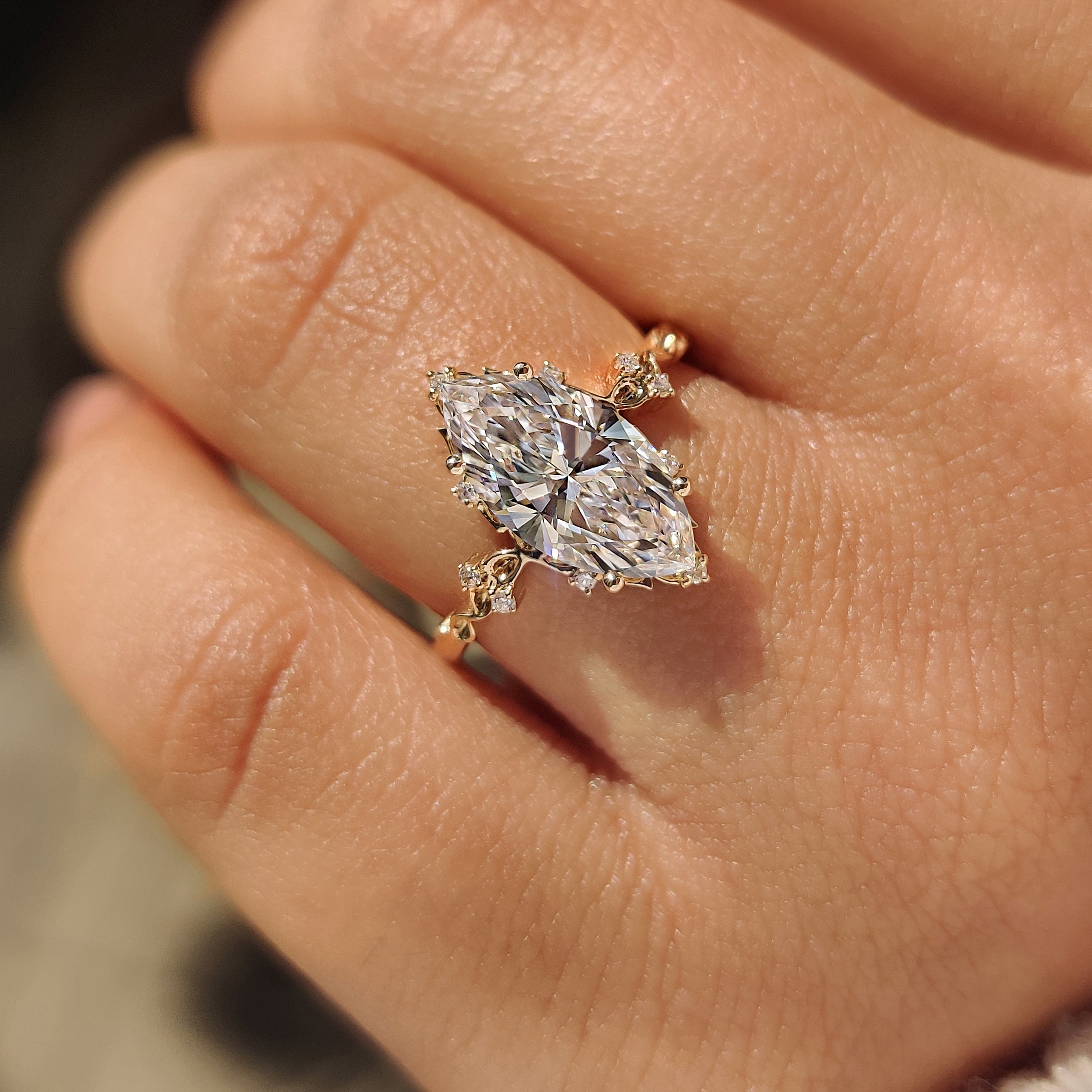 Vintage style marquise diamond ring with round side stones.
