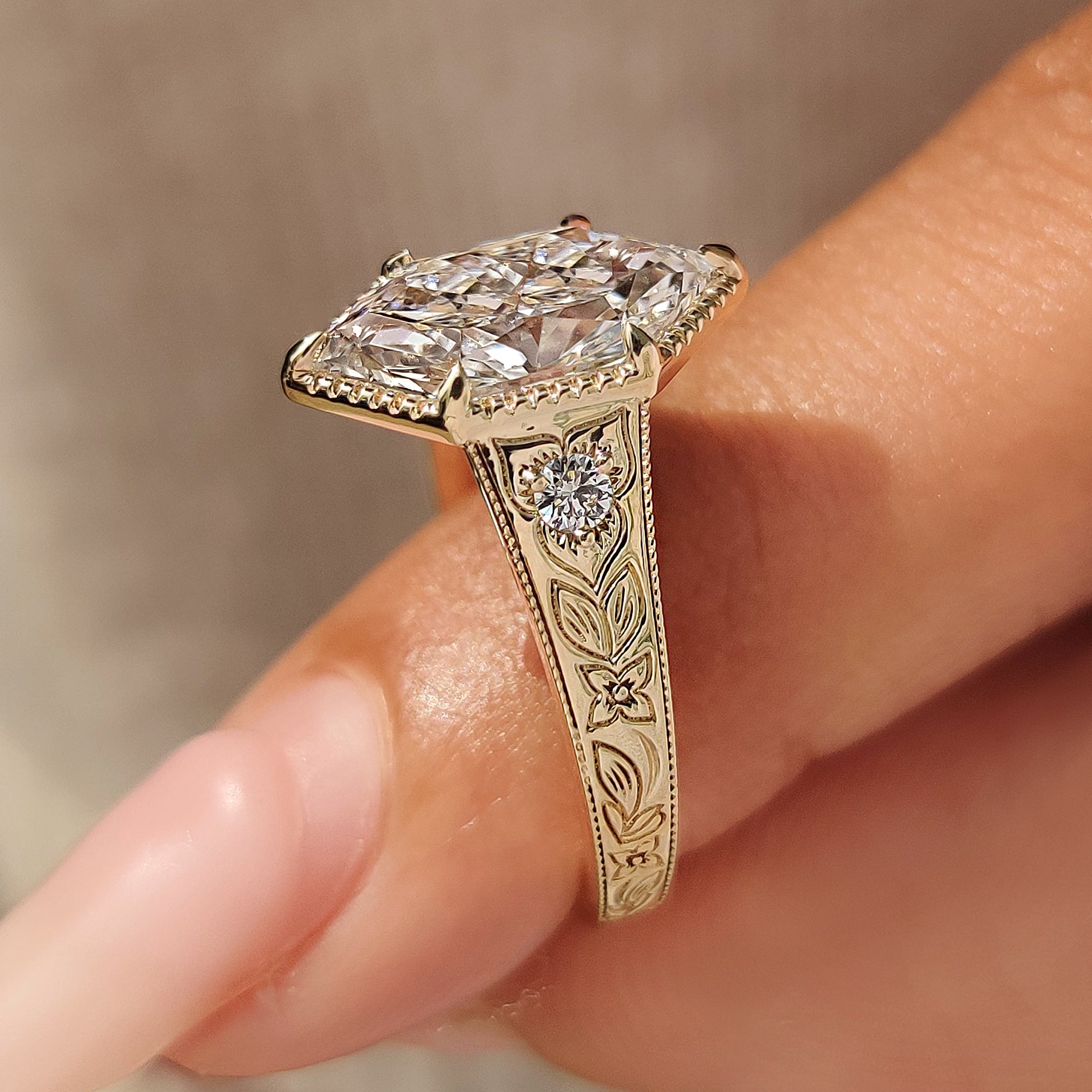 Hand engraved leaf and floral patterns across the yellow gold shank.
