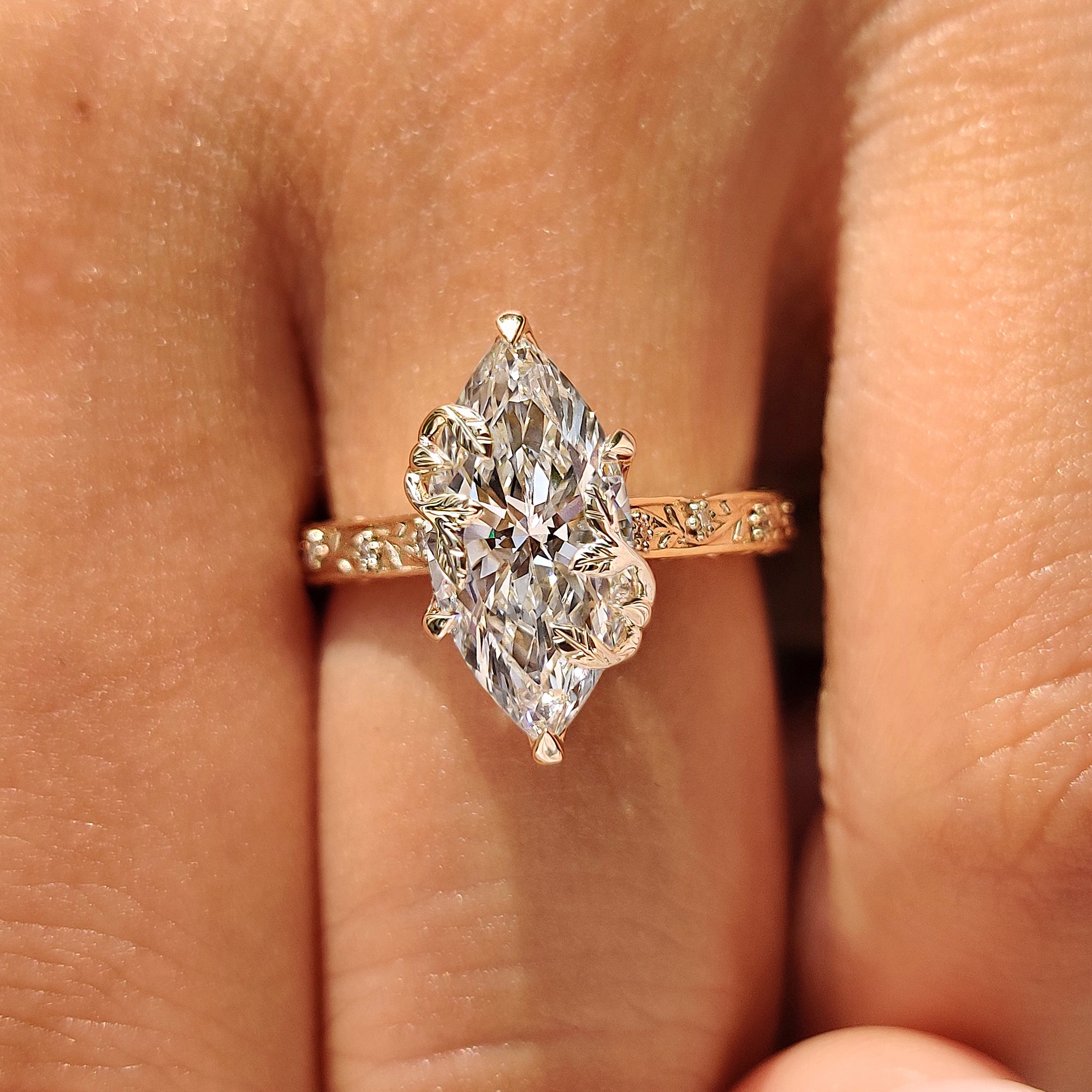 Six claw prong marquise diamond ring with floral band.

