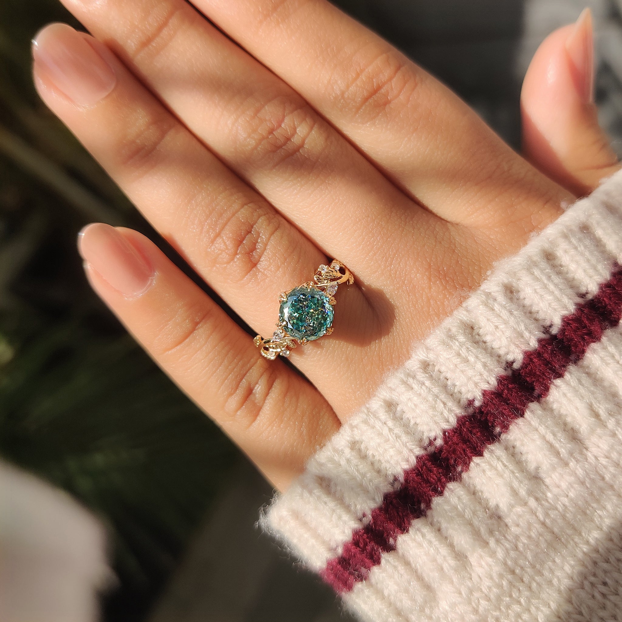 Cyan blue moissanite ring with marquise and round side stones.
