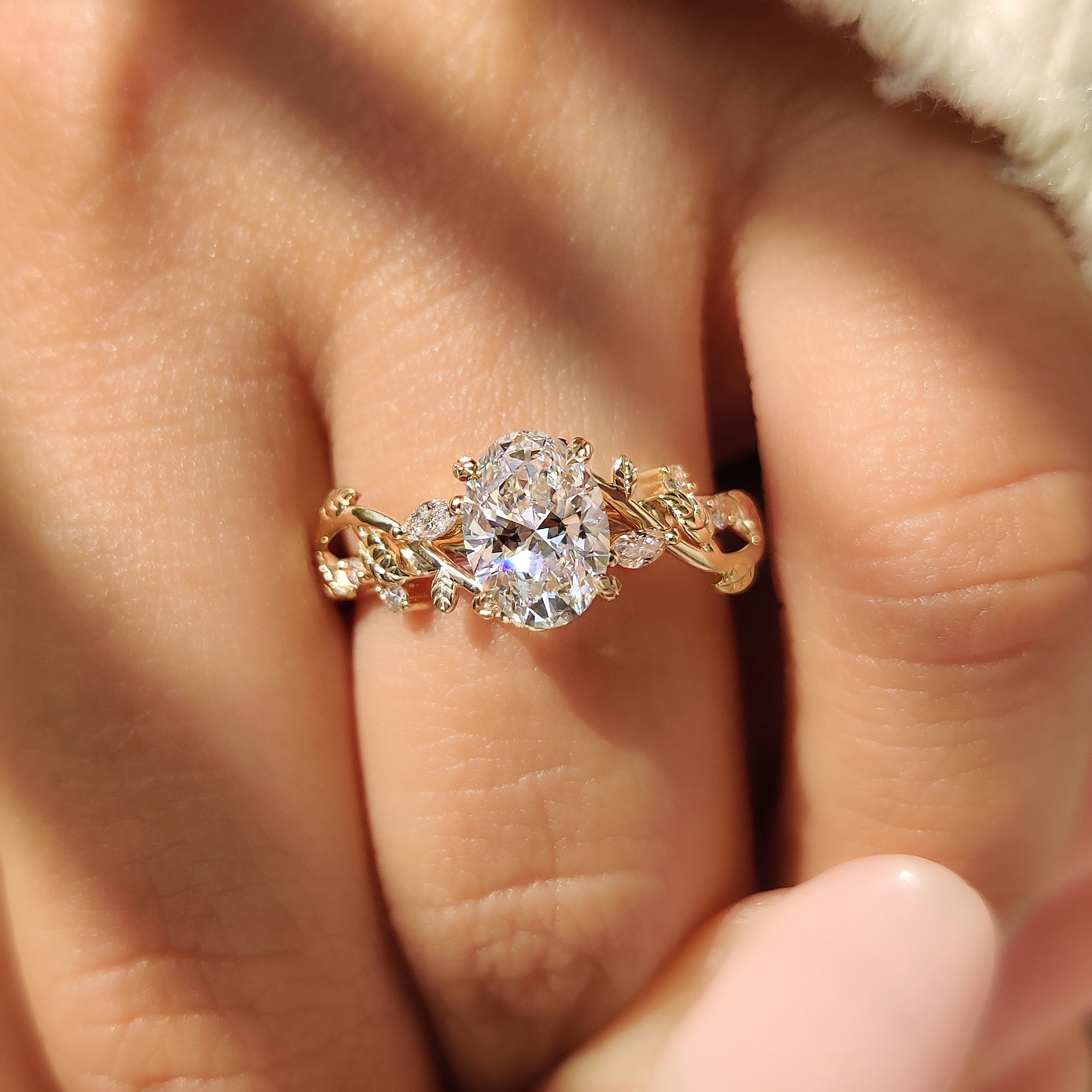 Oval diamond ring with marquise and round side stones.
