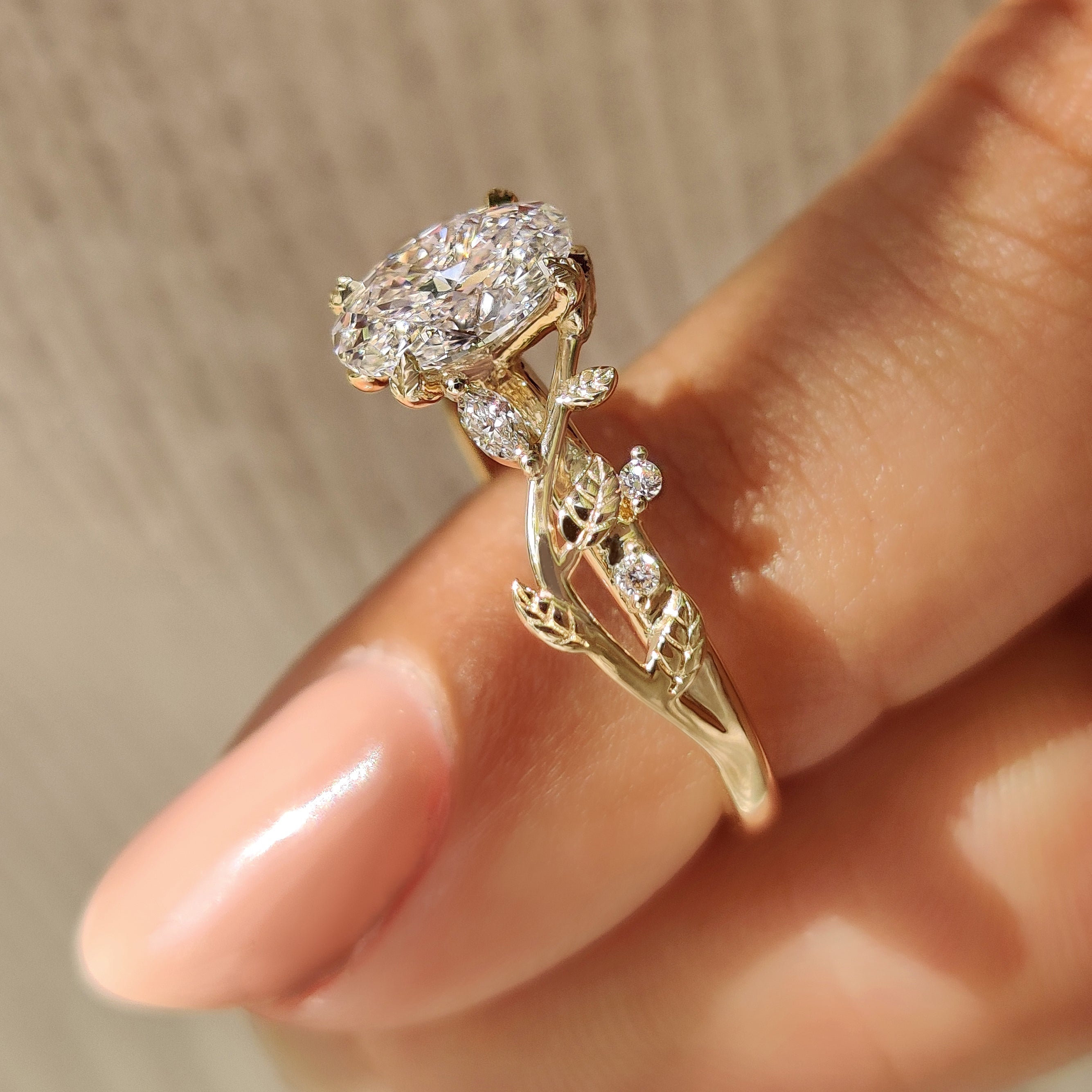 Leaf and vine inspired oval diamond engagement ring design.
