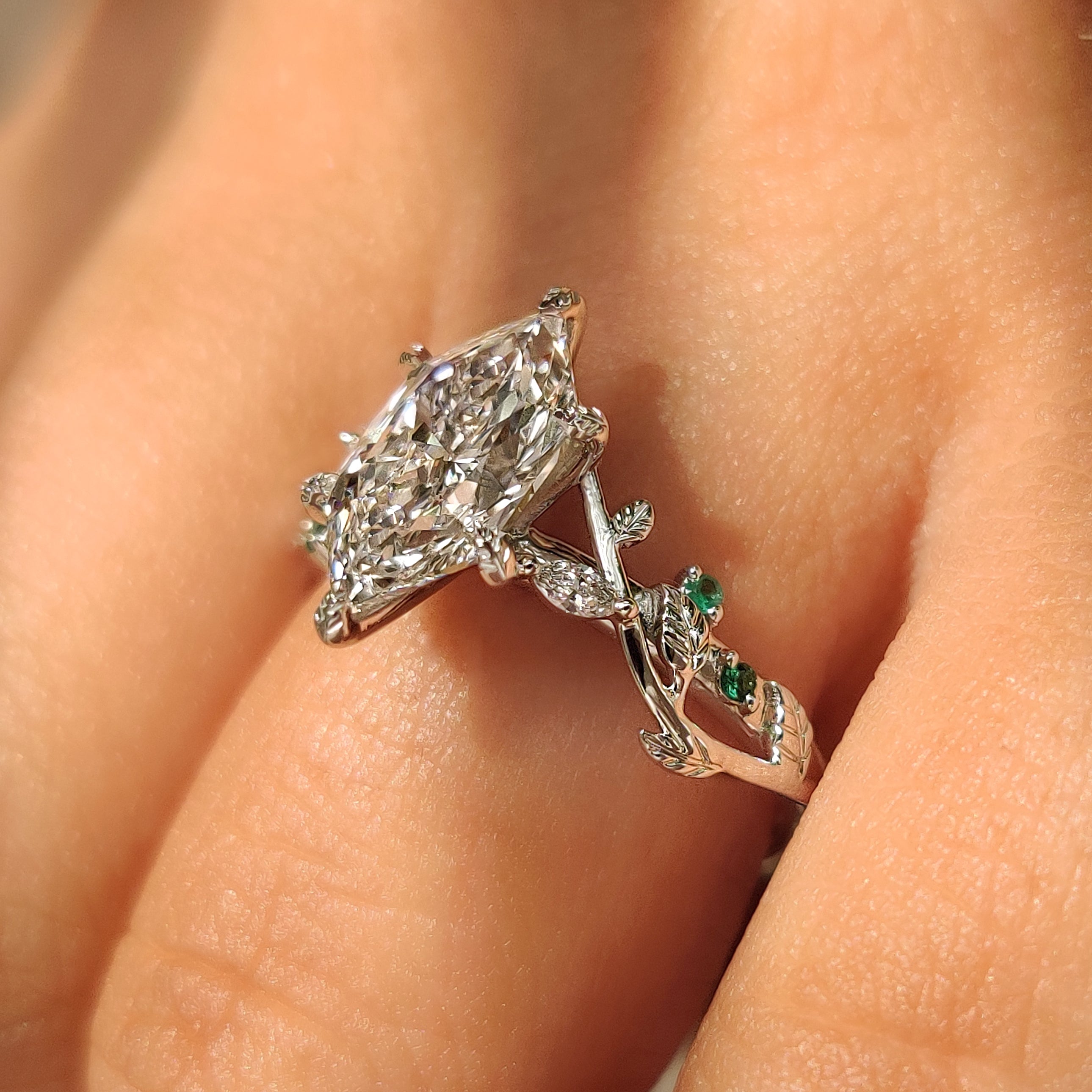 Diamond ring with green emerald accents and marquise stones
