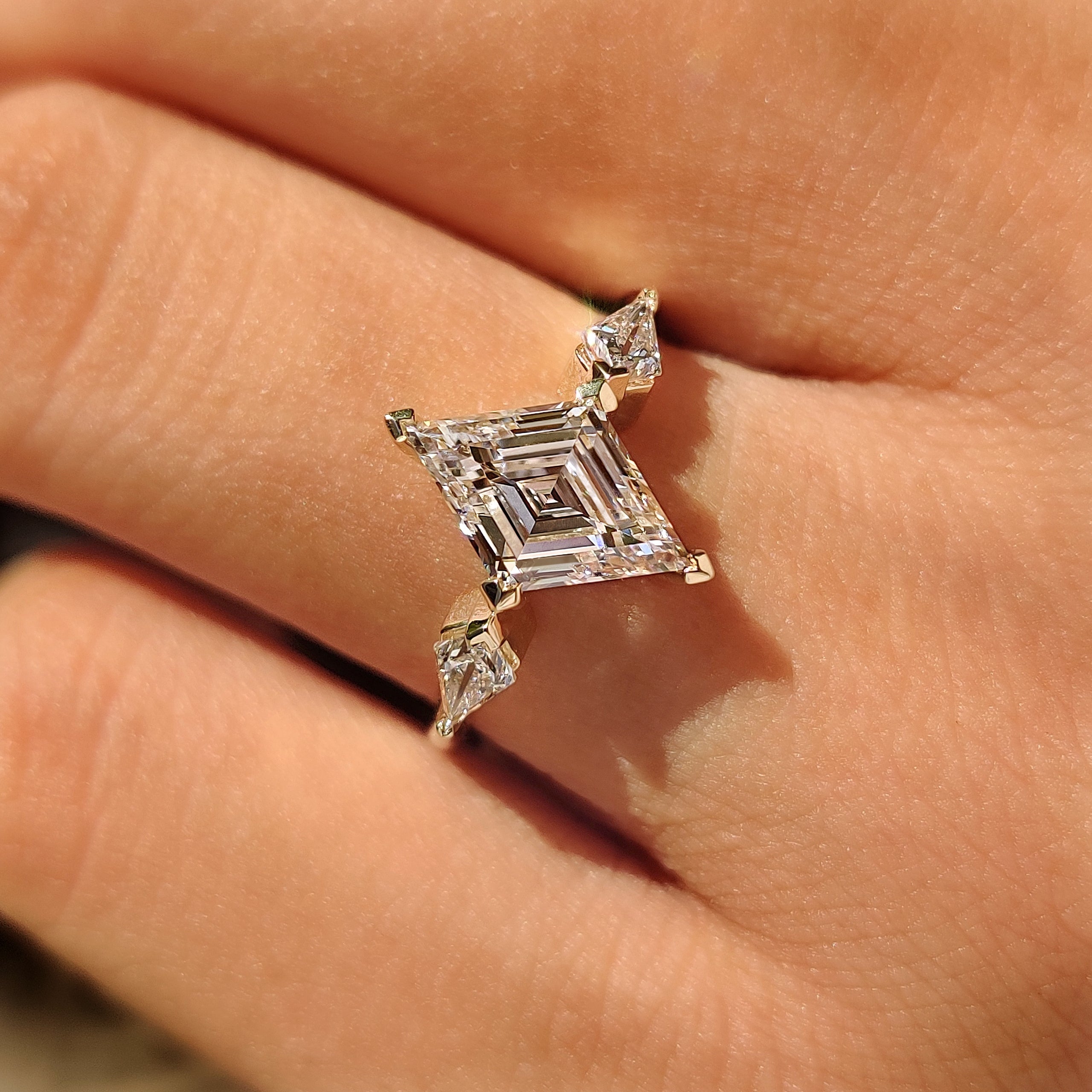 Lozenge cut diamond ring with V compass prong setting
