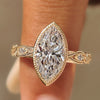 Marquise bezel set engagement ring with milgrain border.
