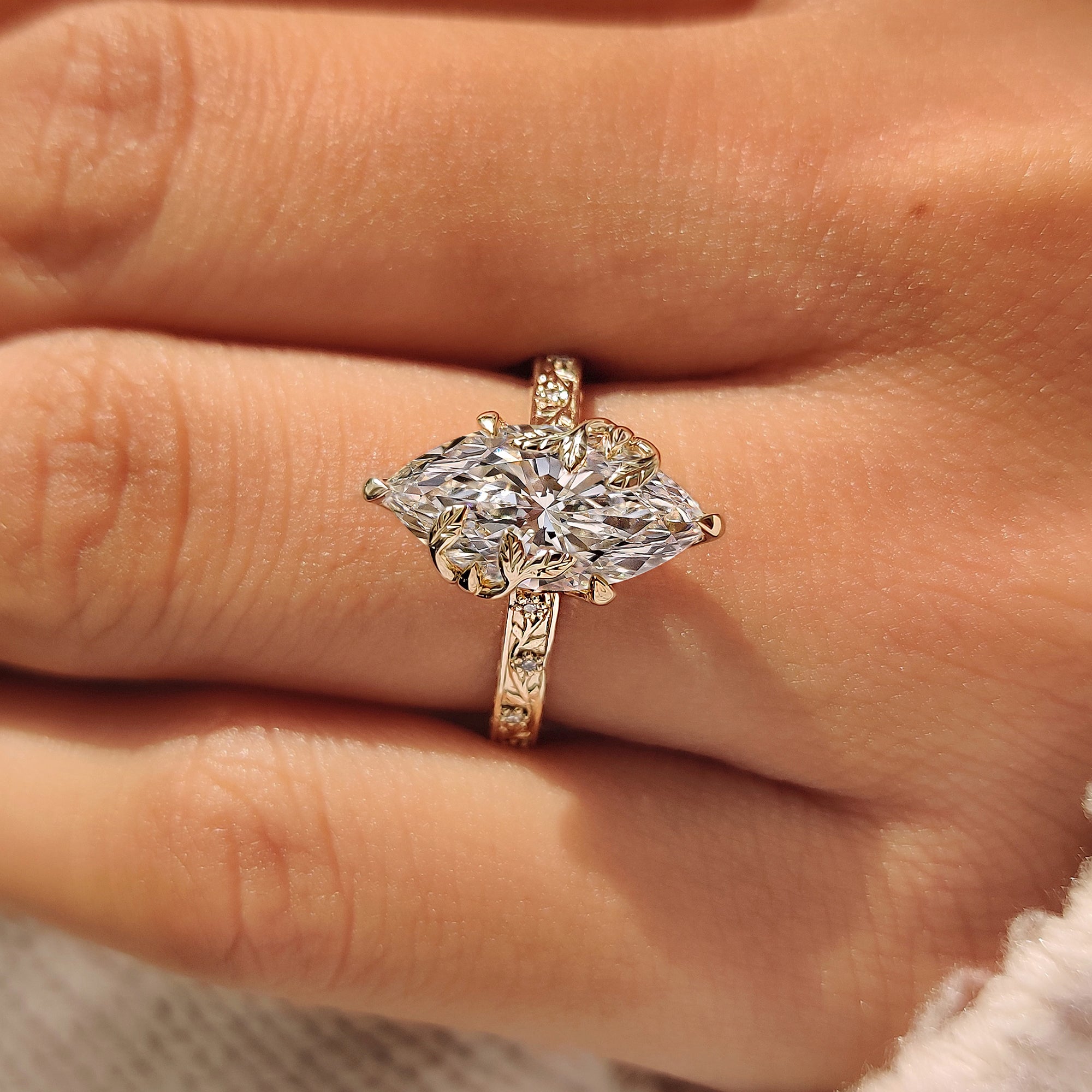 Engraved floral band on marquise cut diamond ring.
