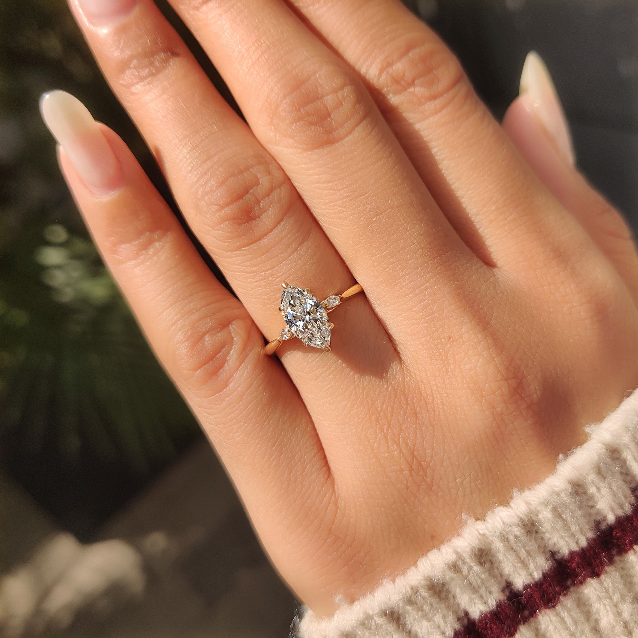 Marquise engagement ring with tulip setting and side stones.
