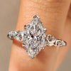 Marquise cut diamond ring with round side stone accents
