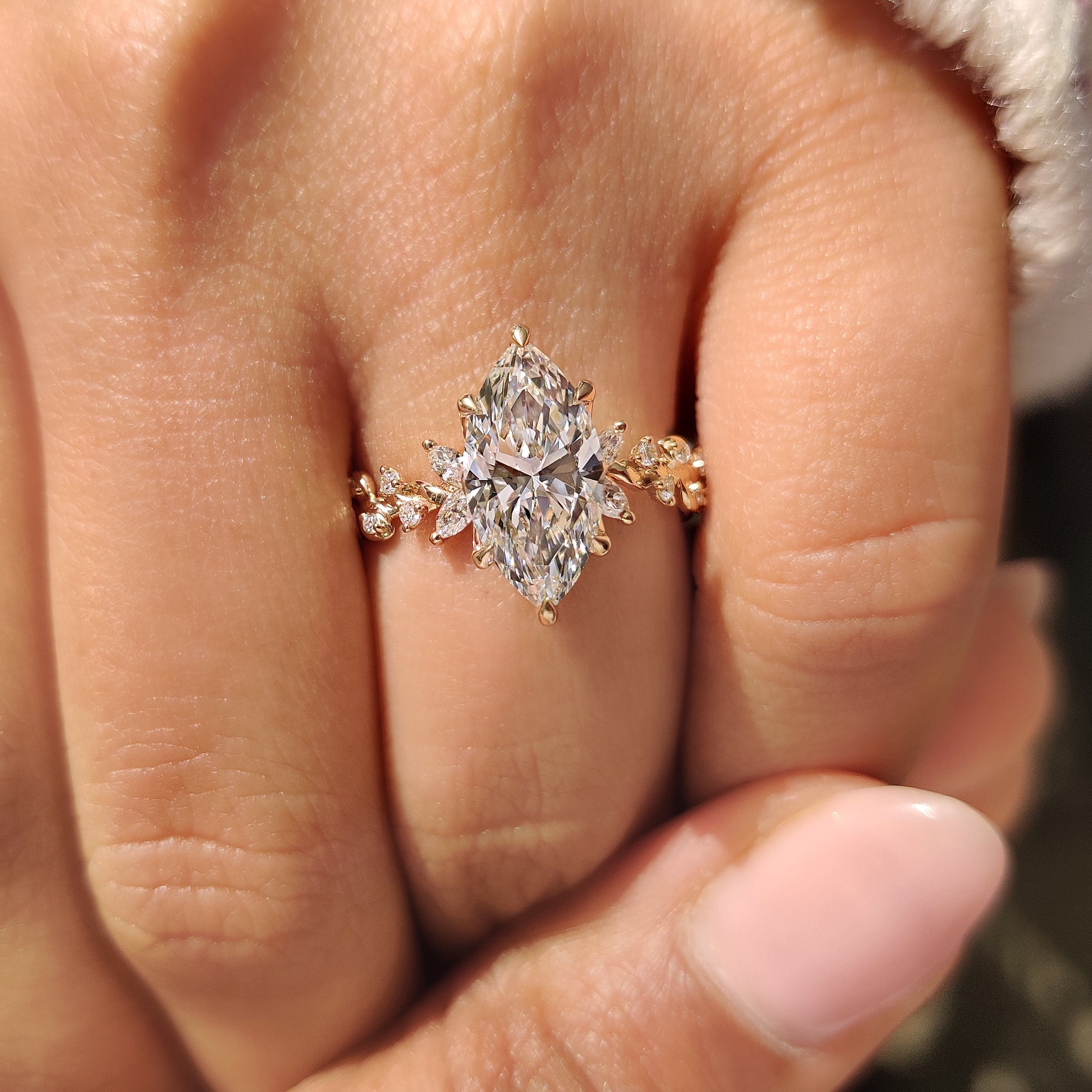 Lab grown marquise diamond ring with six claw prongs.
