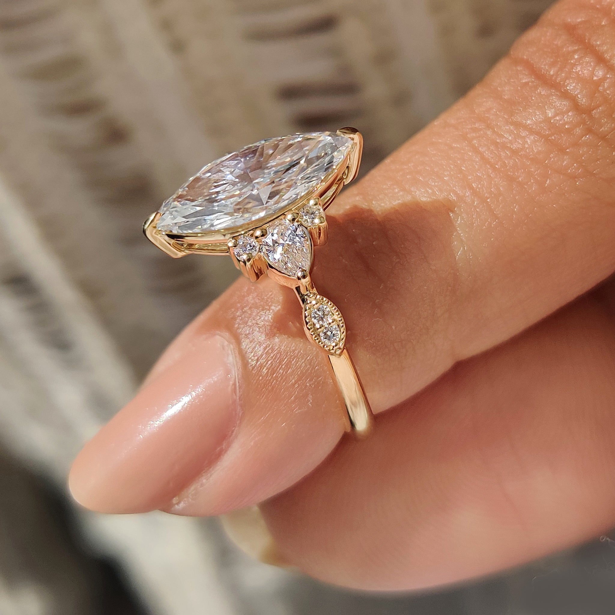 Marquise ring with pear and round side diamonds design.
