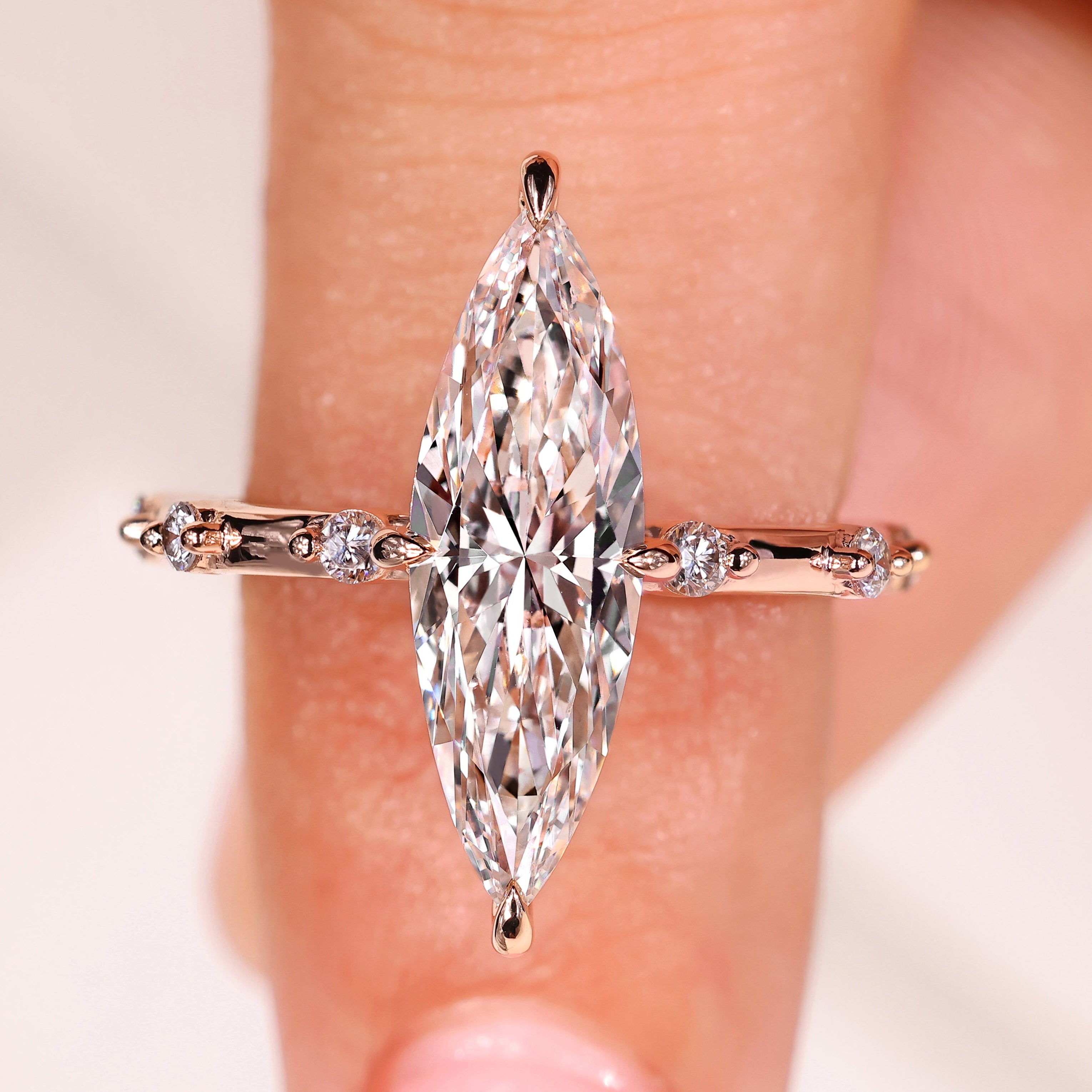 Elongated marquise engagement ring with distance pave diamonds
