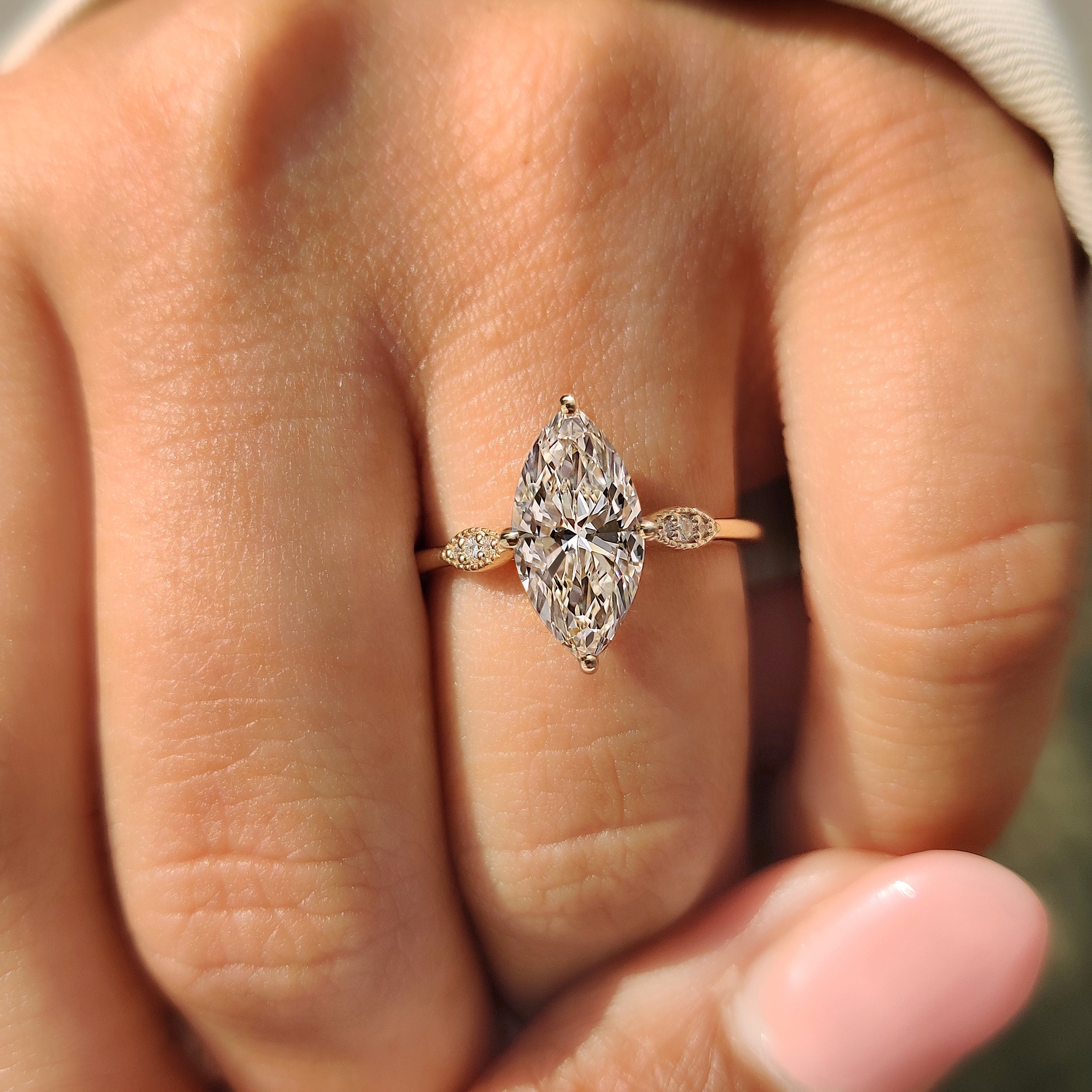 Marquise cut ring with cathedral setting and milgrain border.

