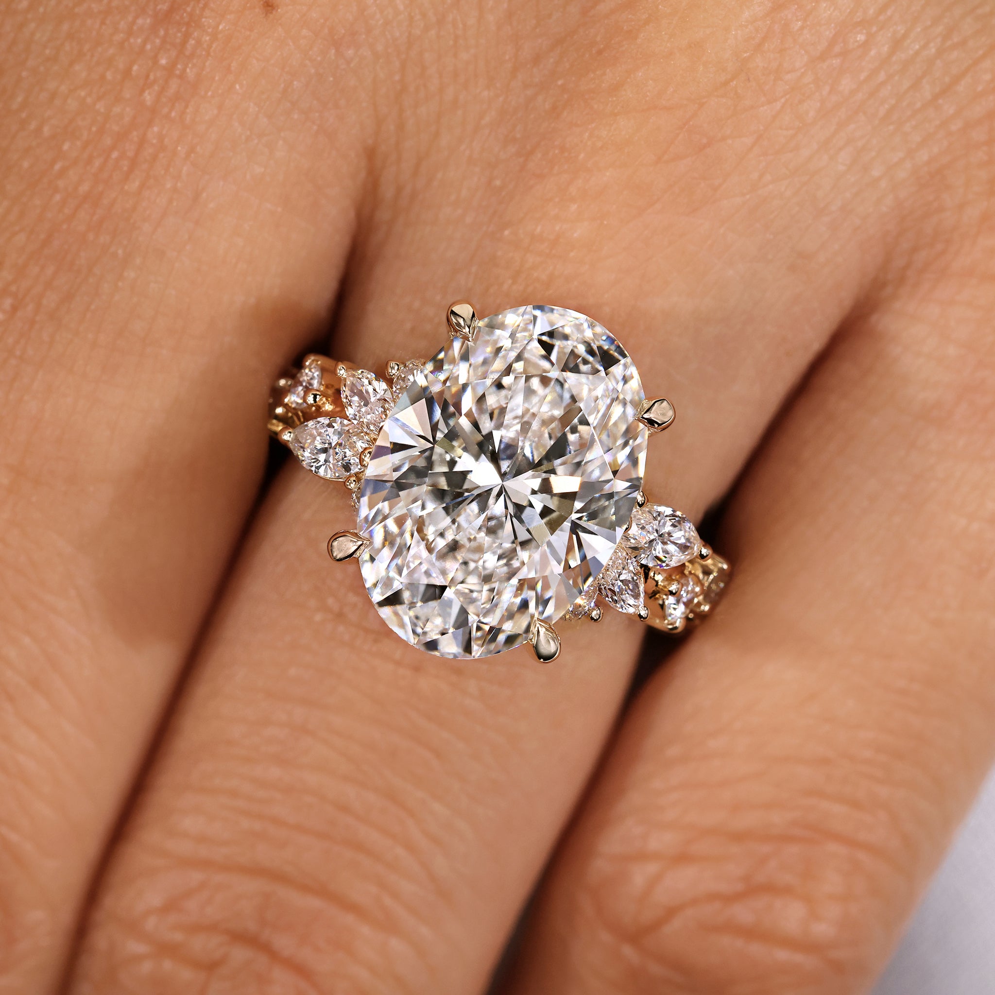 Handmade oval cut diamond ring featuring marquise and round diamond detailing.
